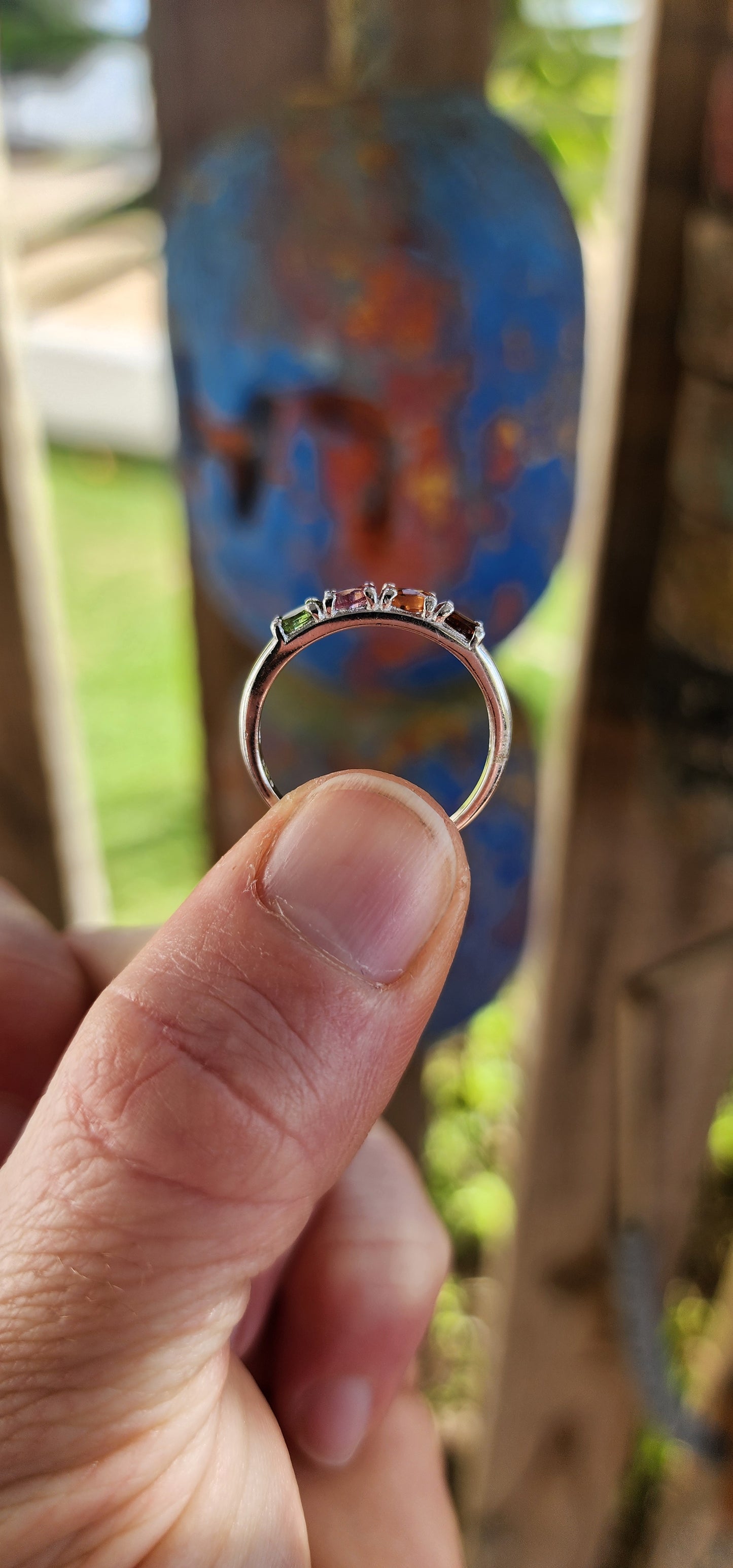 Let your fingers tell a story of color and wonder with this enchanting sterling silver half-eternity ring.