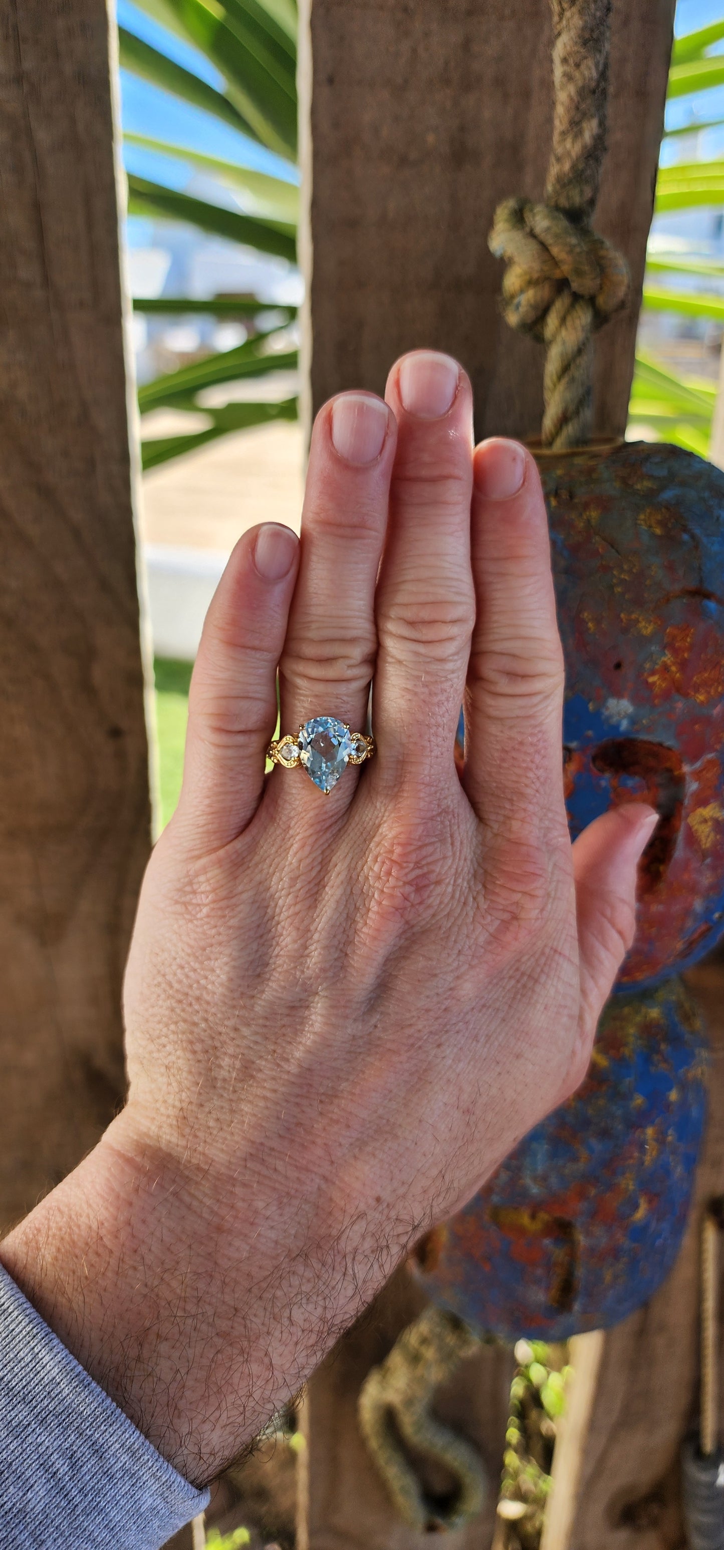 Ocean’s Crown – A Sky Blue Topaz Masterpiece.
Kissed by the ocean’s breath and wrapped in golden sunlight—this ring looks as though it was plucked from the treasure chest of a sea-born queen.
