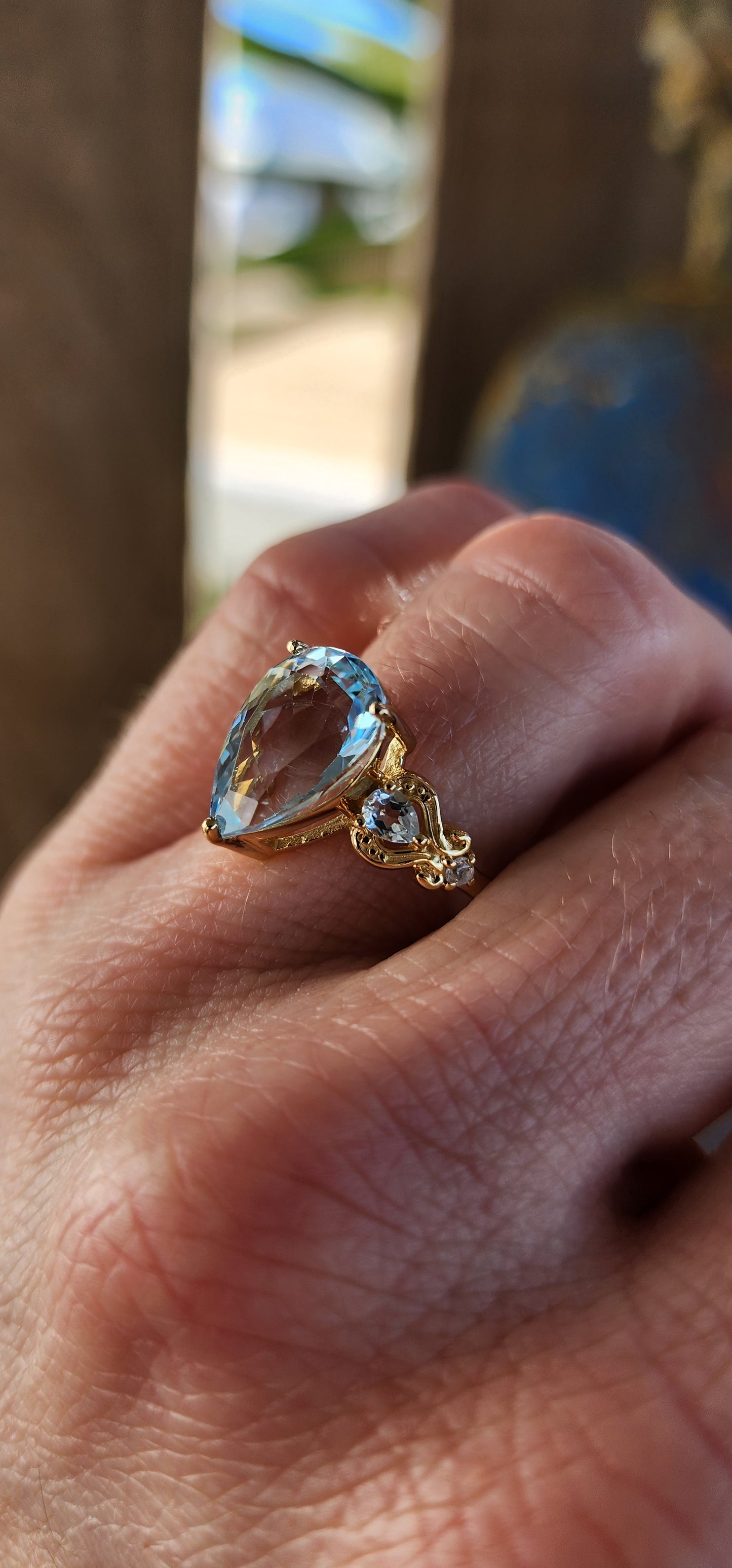Ocean’s Crown – A Sky Blue Topaz Masterpiece.
Kissed by the ocean’s breath and wrapped in golden sunlight—this ring looks as though it was plucked from the treasure chest of a sea-born queen.