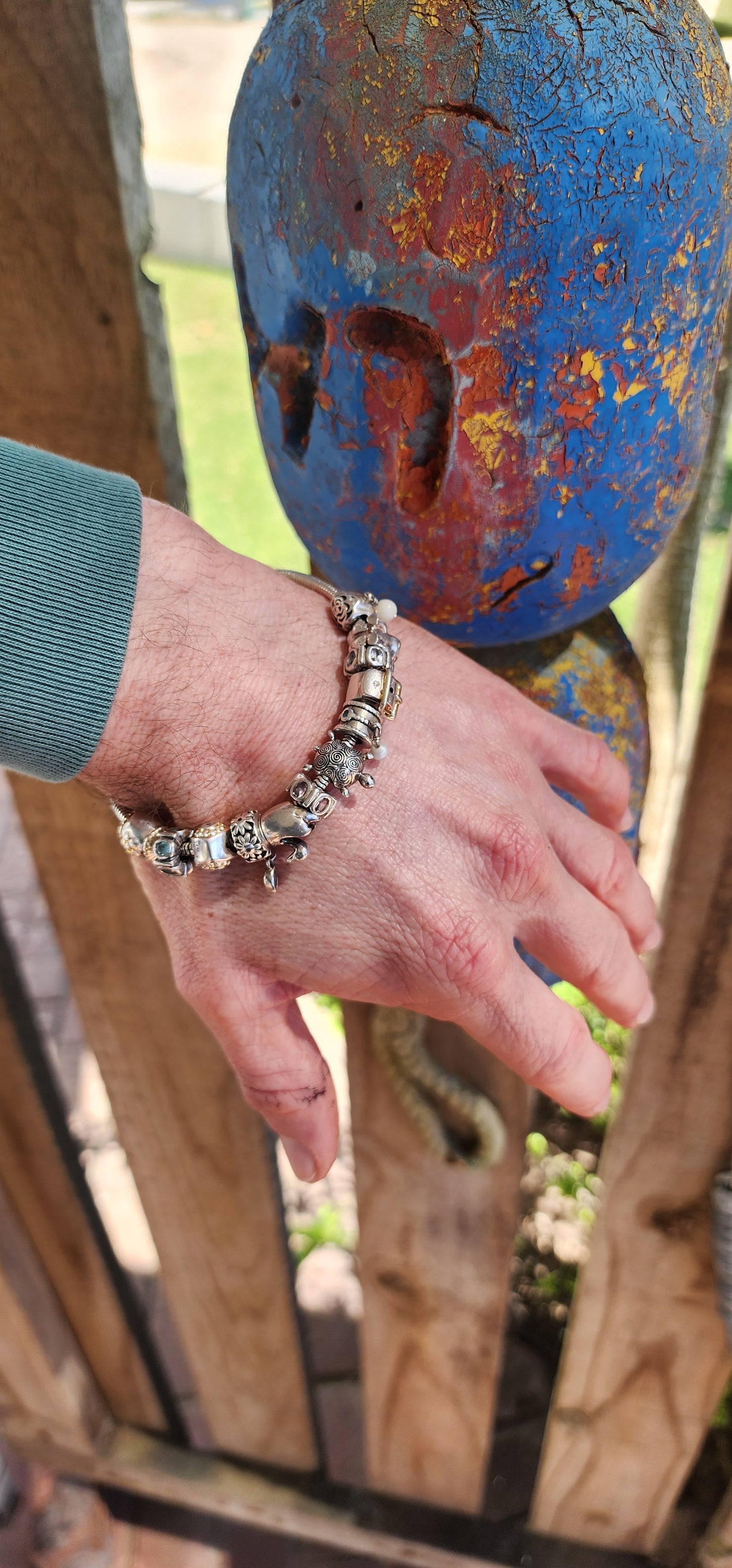 This delightful creation is a designer sterling silver snake chain charm bracelet by Donna Mia, brimming with character, sparkle, and storytelling.