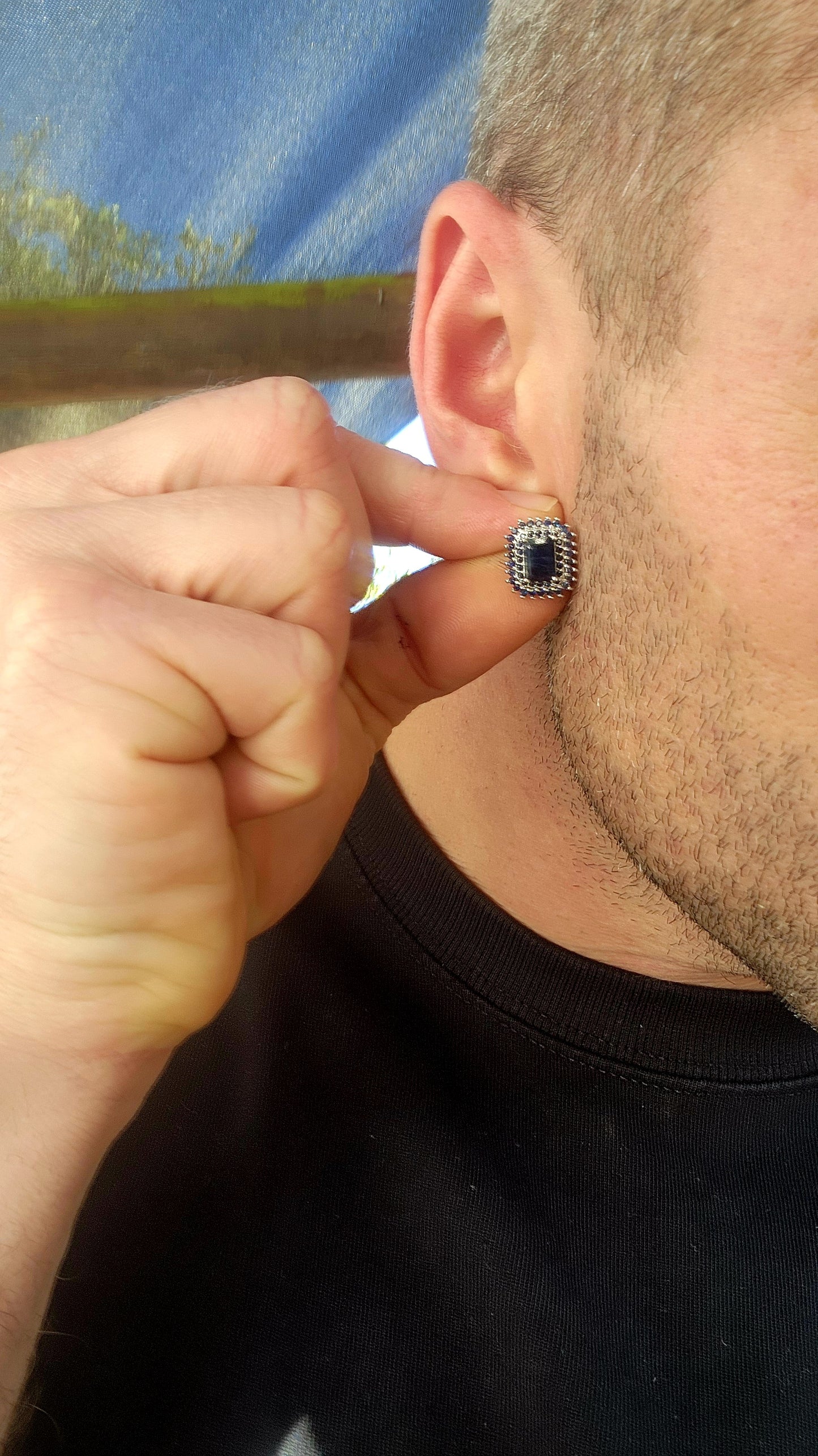 Striking and regal, these sterling silver stud earrings each feature a richly colored emerald-cut deep blue sapphire at the center.