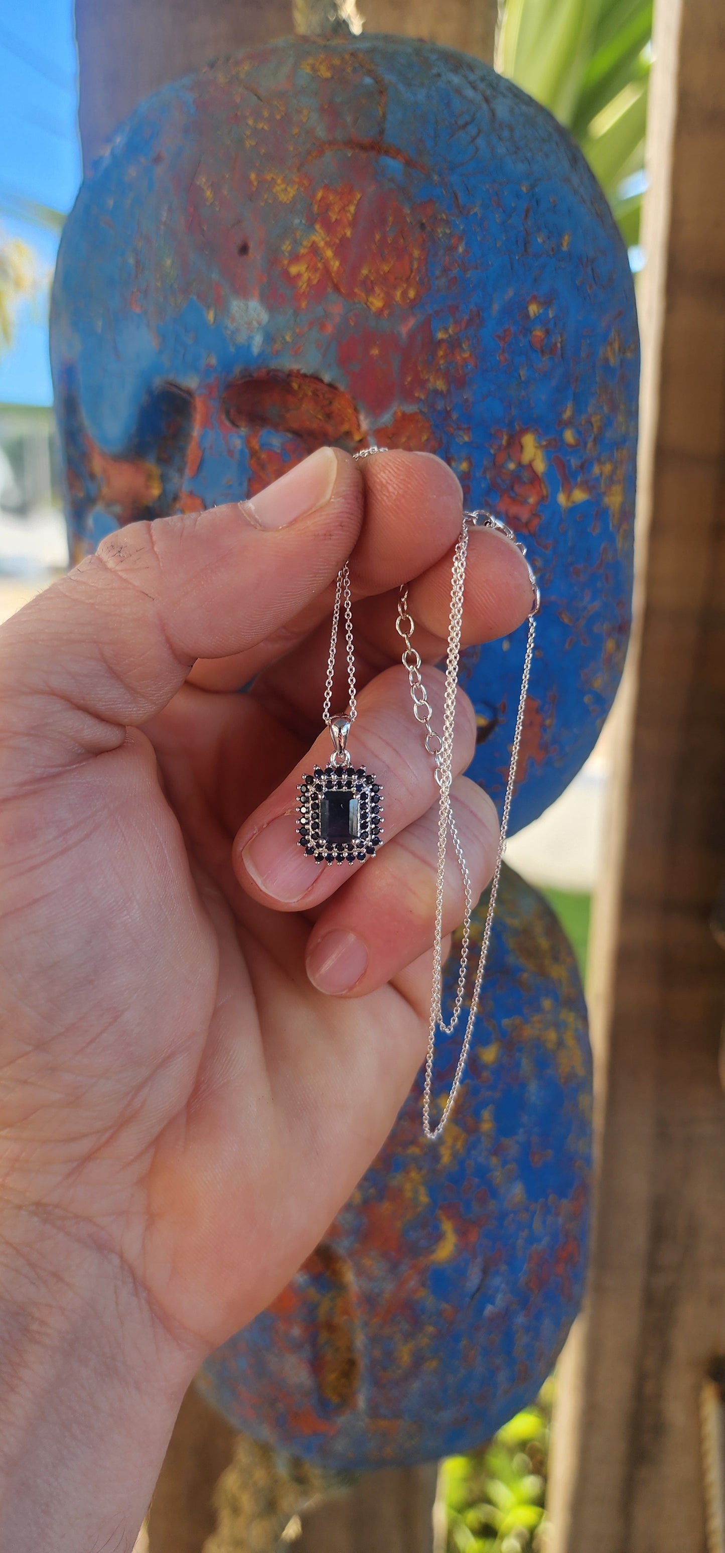 Elegant and timeless, this pendant features a richly saturated emerald-cut deep blue sapphire as its centerpiece, prong-set to capture and reflect light with depth and intensity.