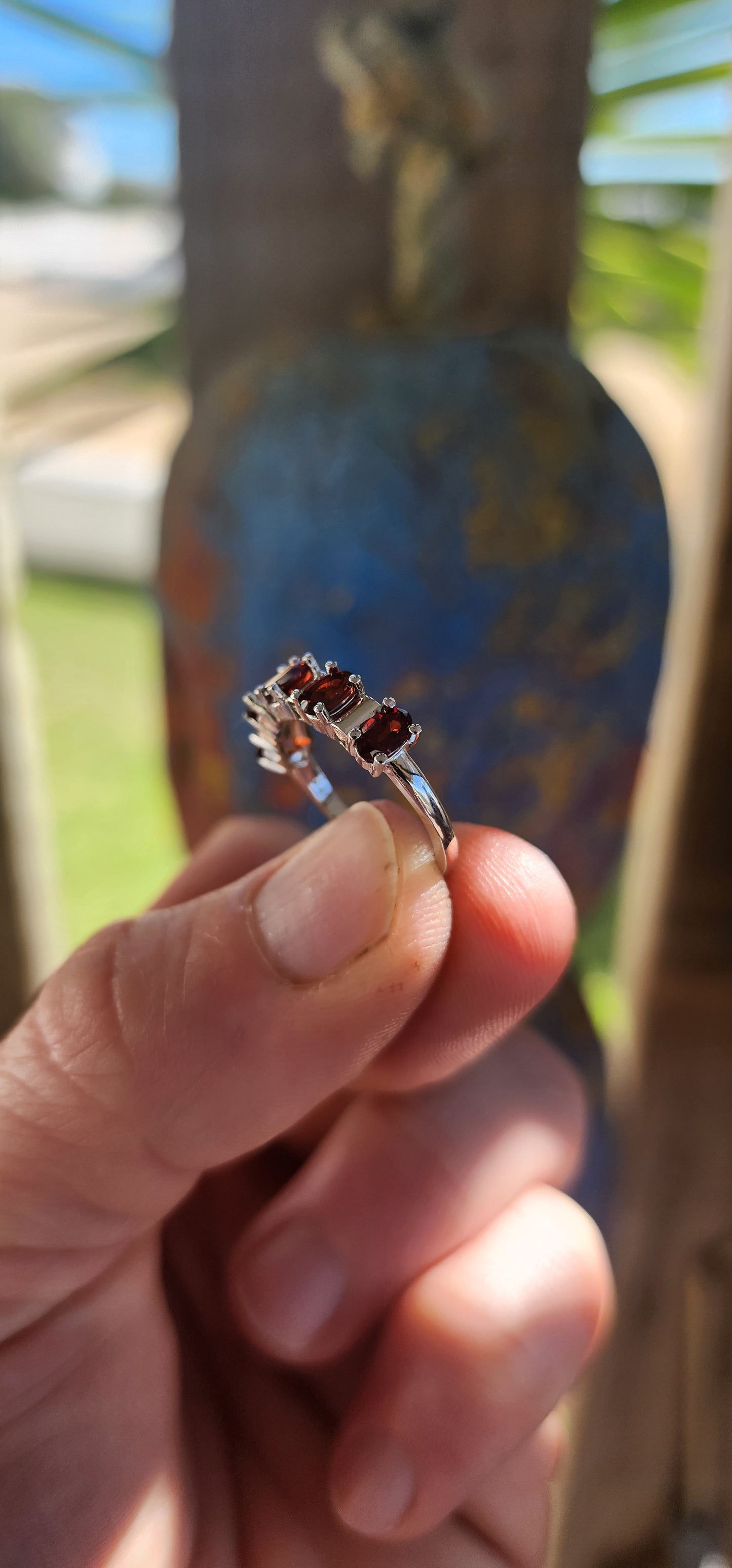 This sterling silver half-eternity ring is a timeless and elegant piece, featuring five richly hued oval-cut garnet gemstones.