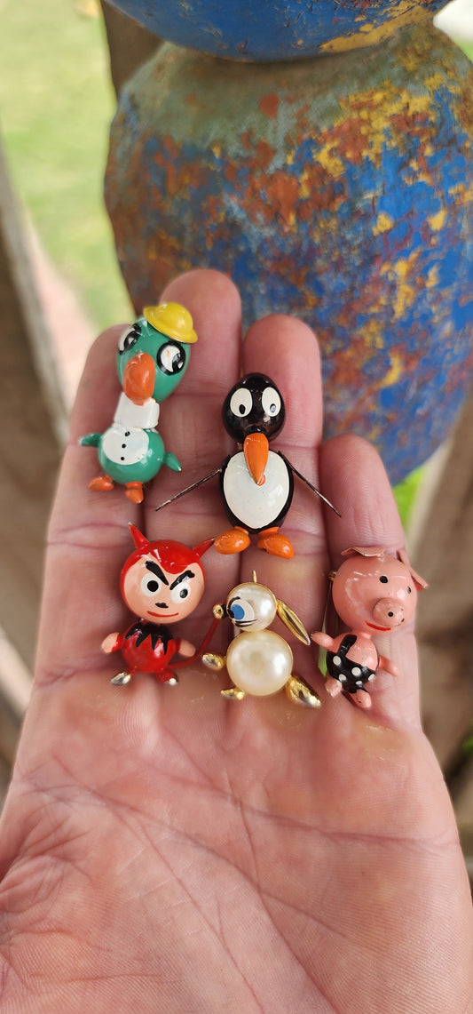 Playful collection of 5x Art Deco–era circa 1920s–1930s novelty brooches, crafted in copper with hand-painted enamel details that burst with vintage charm and personality.