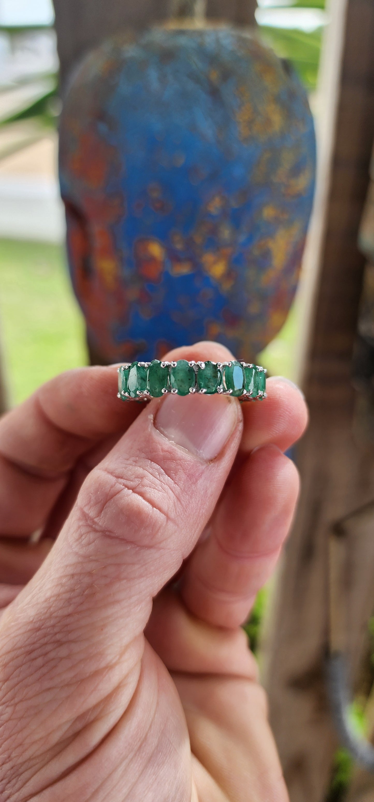 This glorious unisex sterling silver full eternity ring is a never-ending parade of 18 glowing oval-cut emeralds.