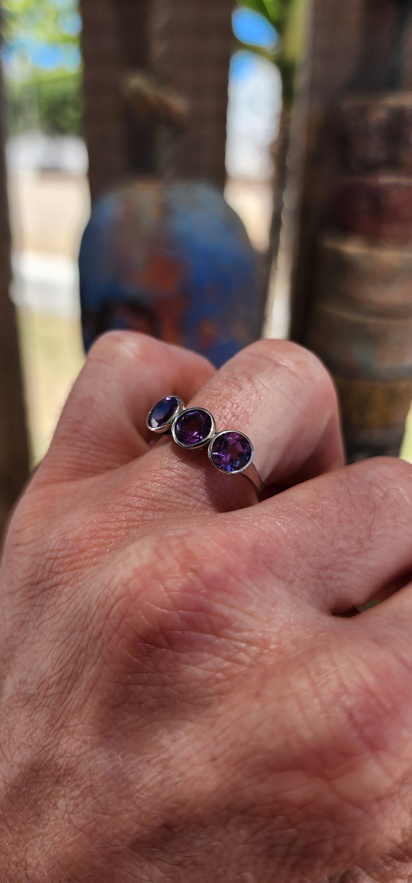 This sterling silver trilogy ring is a dreamy celebration of amethyst magic, set with three round faceted amethyst gemstones that glow in juicy shades of violet, plum and royal purple.