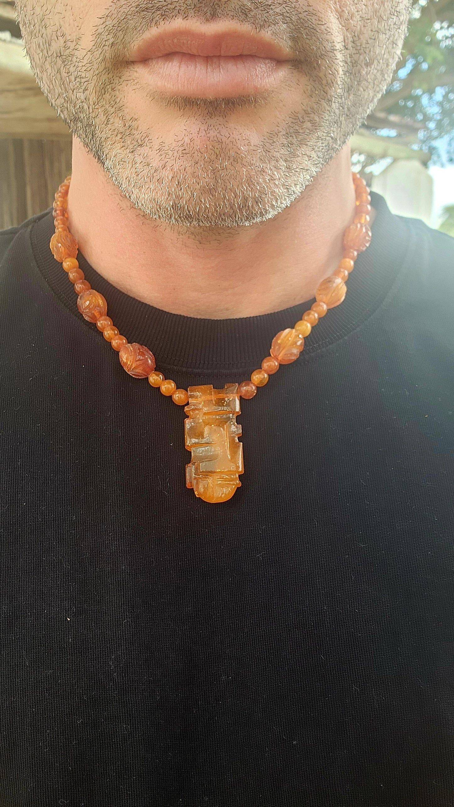 This marvelous Art Deco era (circa 1920s) Baltic amber necklace is crafted in a striking Aztec / Mesoamerican revival style.