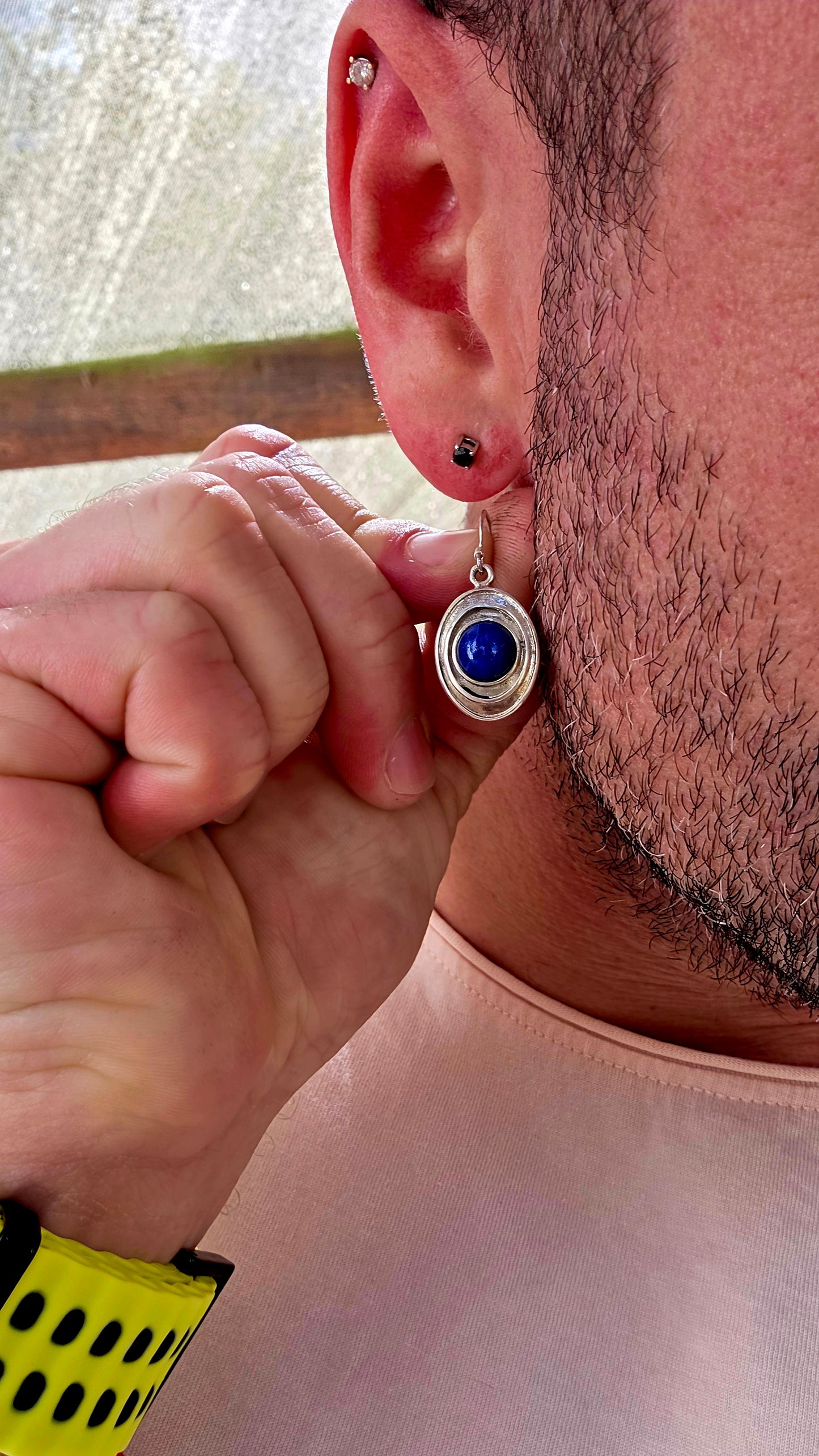 This striking pair of sterling silver dangle earrings features an oval-shaped, layered frame design, each centred with a rich royal-blue lapis lazuli cabochon.
