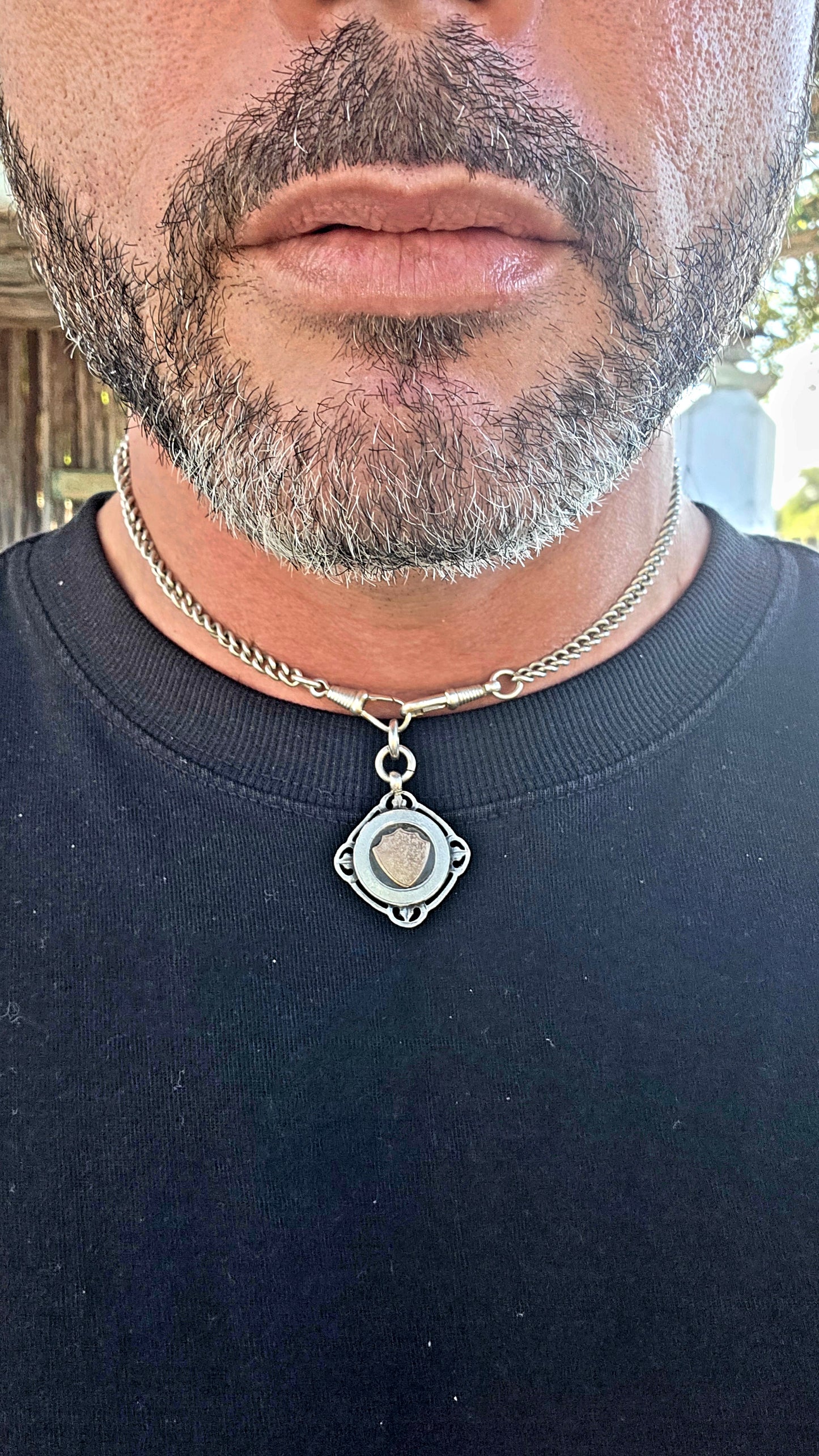 A beautiful antique hallmarked fob shield pendant, crafted in sterling silver and decorated with a raised 9ct rose gold shield cartouche, creating a striking and elegant two-tone contrast.
