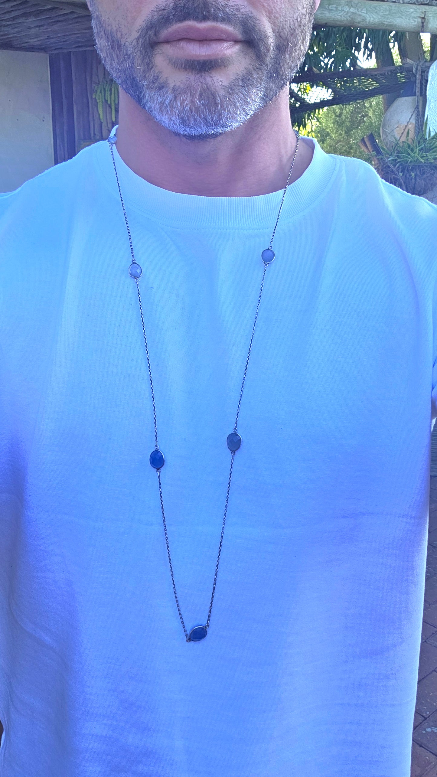 Extra-length sterling silver station-style necklace featuring a delicate scattering of faceted chalcedony gemstones gracefully suspended between fine sterling silver chain links.