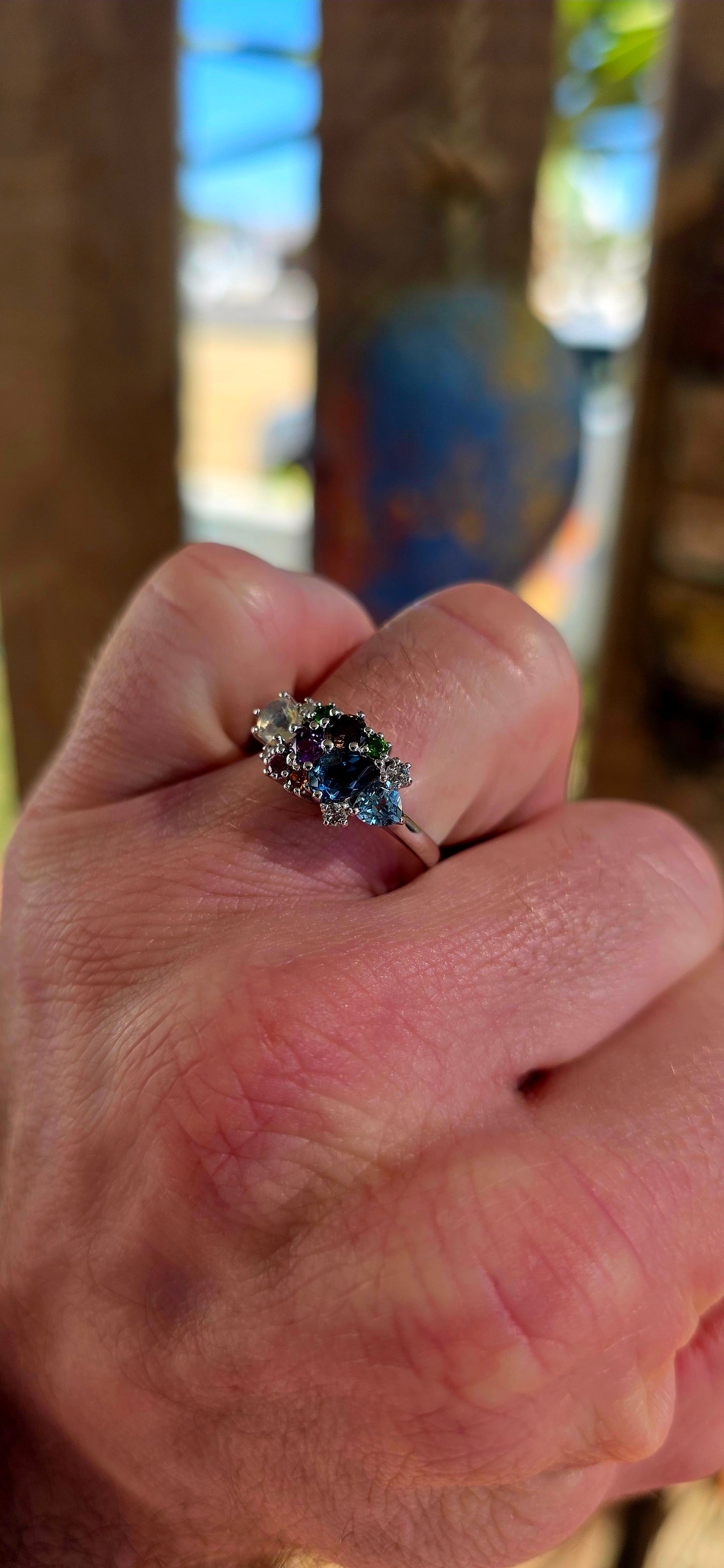 An enchanting sterling silver cluster ring finished in luminous rhodium plating, this marvelous piece feels like a tiny treasure chest of gemstones gathered from across the cosmos.