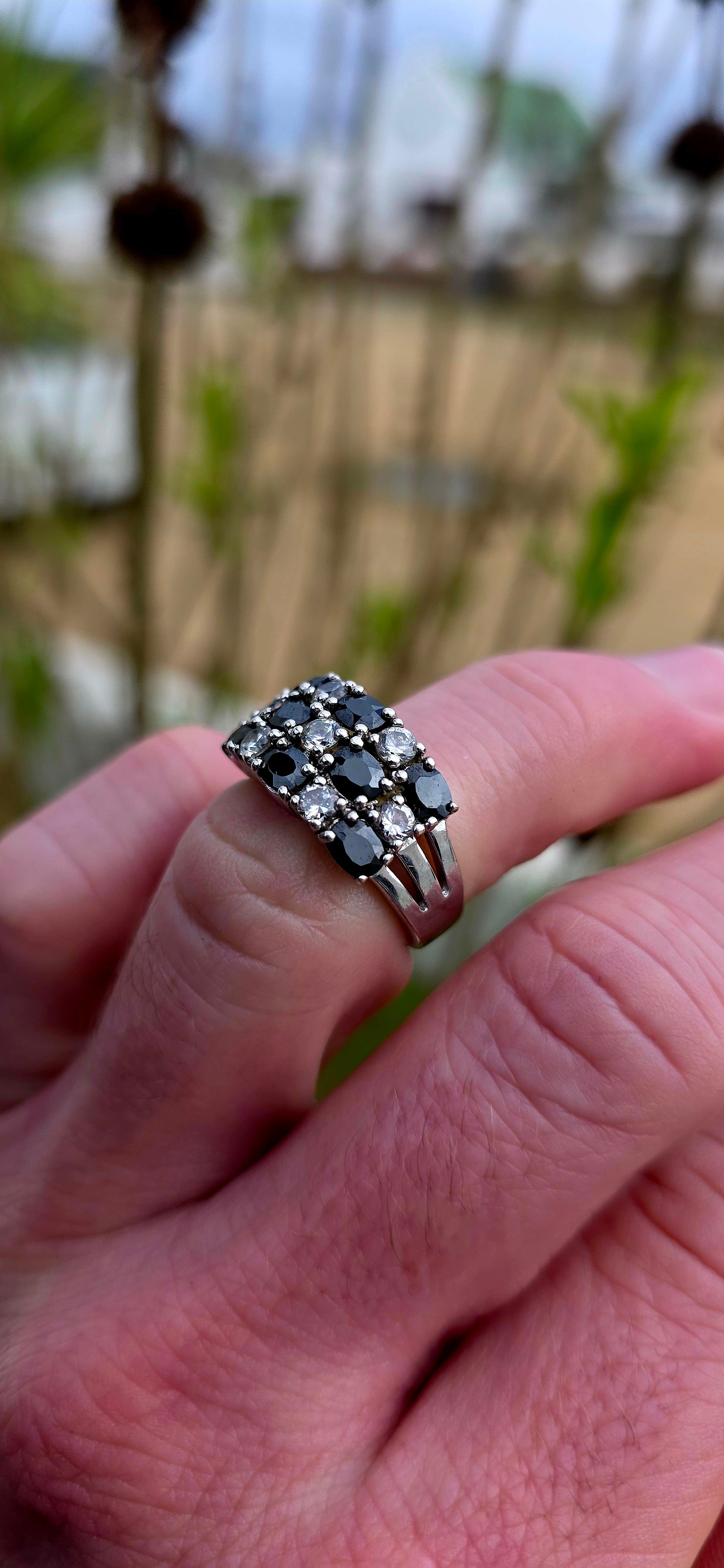 Striking and chunky sterling silver dress ring adorned with a dazzling arrangement of jet-black and crystal-clear cubic zirconia gemstones.