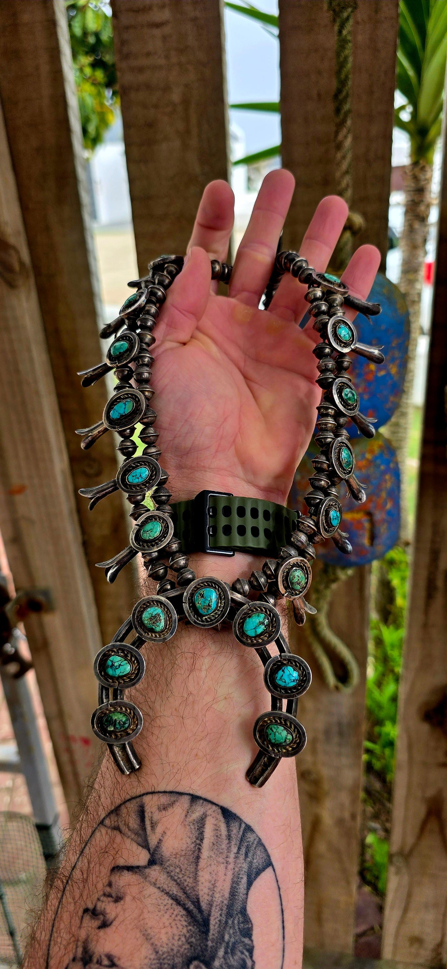 An absolutely breathtaking and exceptionally rare vintage Native American Navajo squash blossom necklace, masterfully handcrafted in sterling silver and adorned with vivid turquoise cabochons throughout.