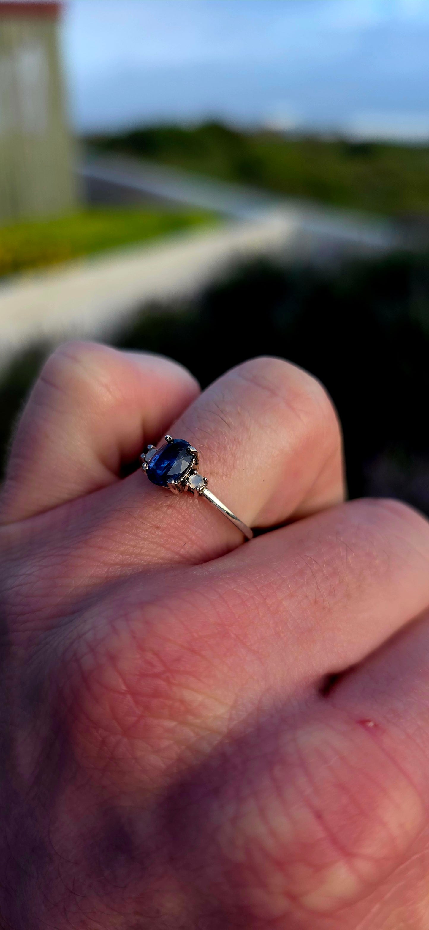 Crafted in sterling silver, this elegant trilogy ring features a captivating oval-cut natural kyanite gemstone at its centre, secured within a classic prong setting.