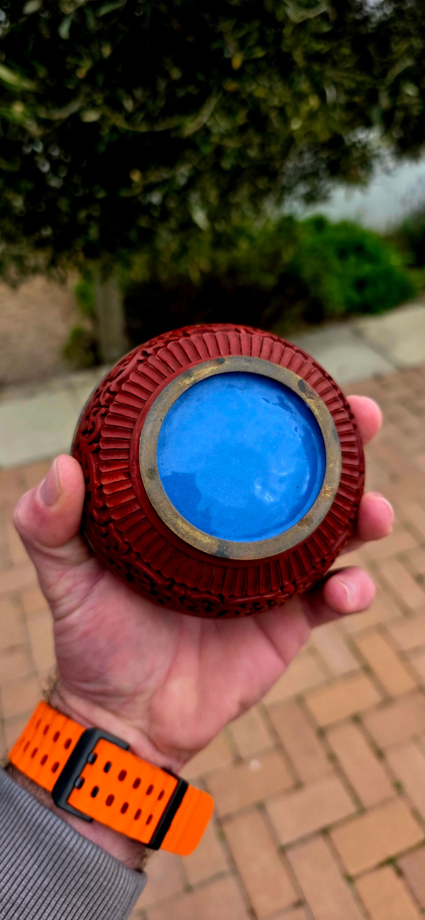 A magnificent Chinese cloisonné enamel and carved cinnabar circular box and lid, beautifully decorated with a tranquil riverside landscape depicting a lone scholar crossing the water toward towering mountains and a secluded pavilion.