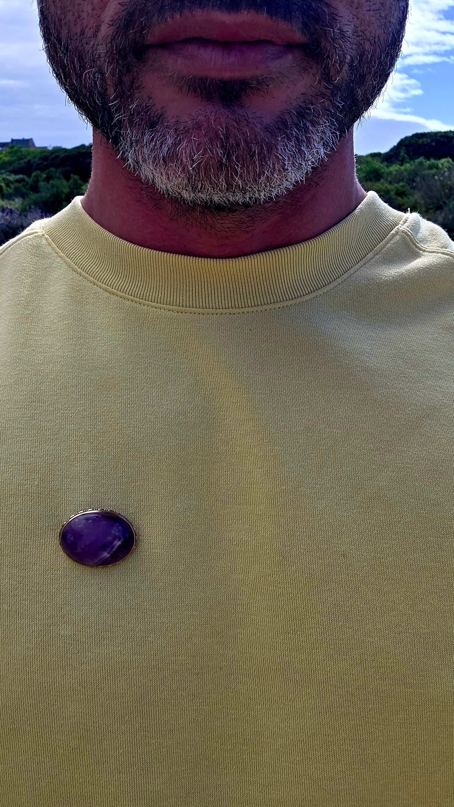 A truly beautiful antique treasure, this 10ct yellow gold brooch showcases a generously sized natural oval amethyst cabochon, celebrated for its rich royal-purple hues and soft, glowing lustre.