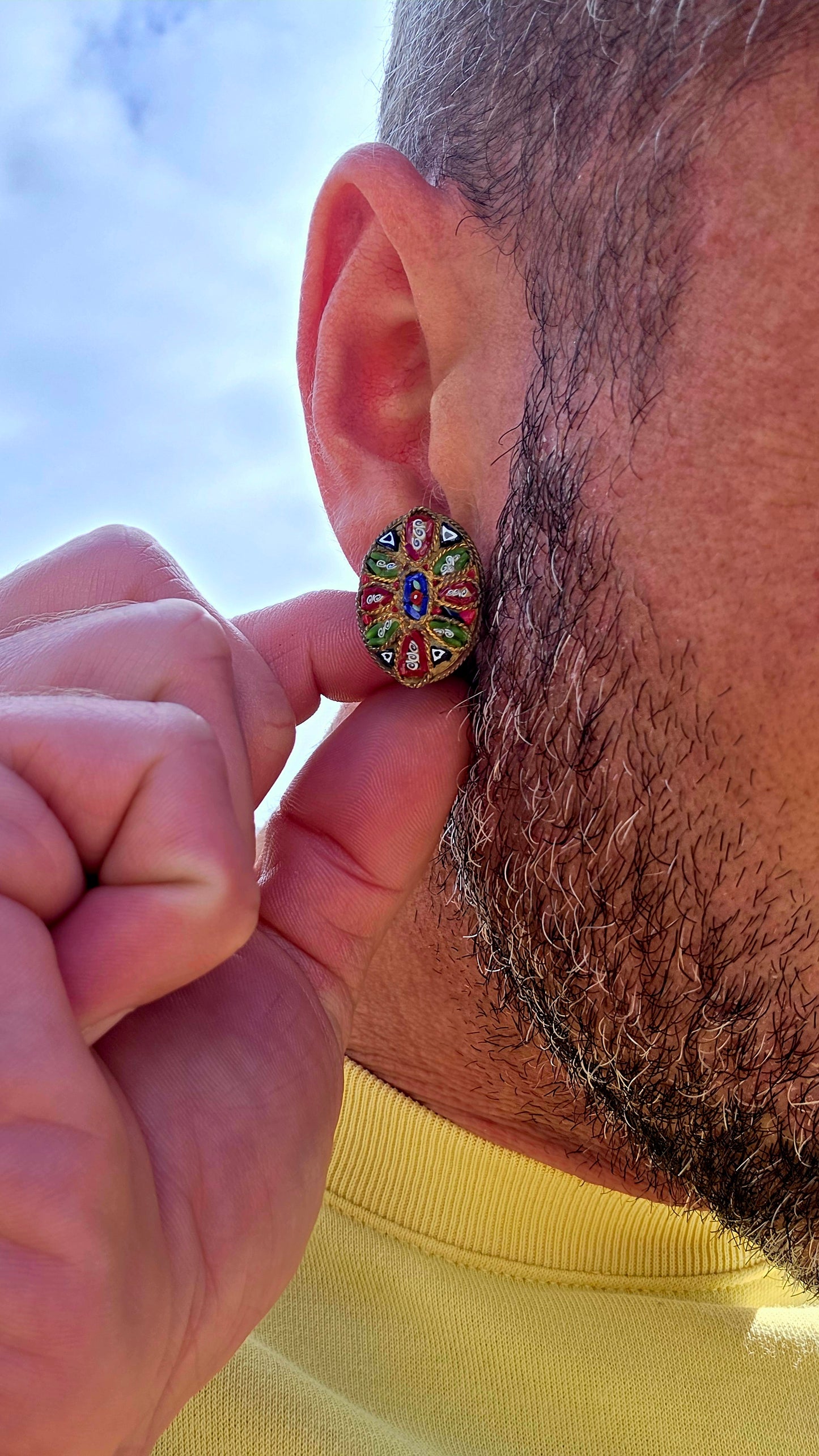 A charming pair of antique oval micro mosaic clip-on earrings, beautifully handcrafted using hundreds of individually placed glass tesserae to create intricate floral and geometric patterns in vibrant shades of red, blue, green, white and black.