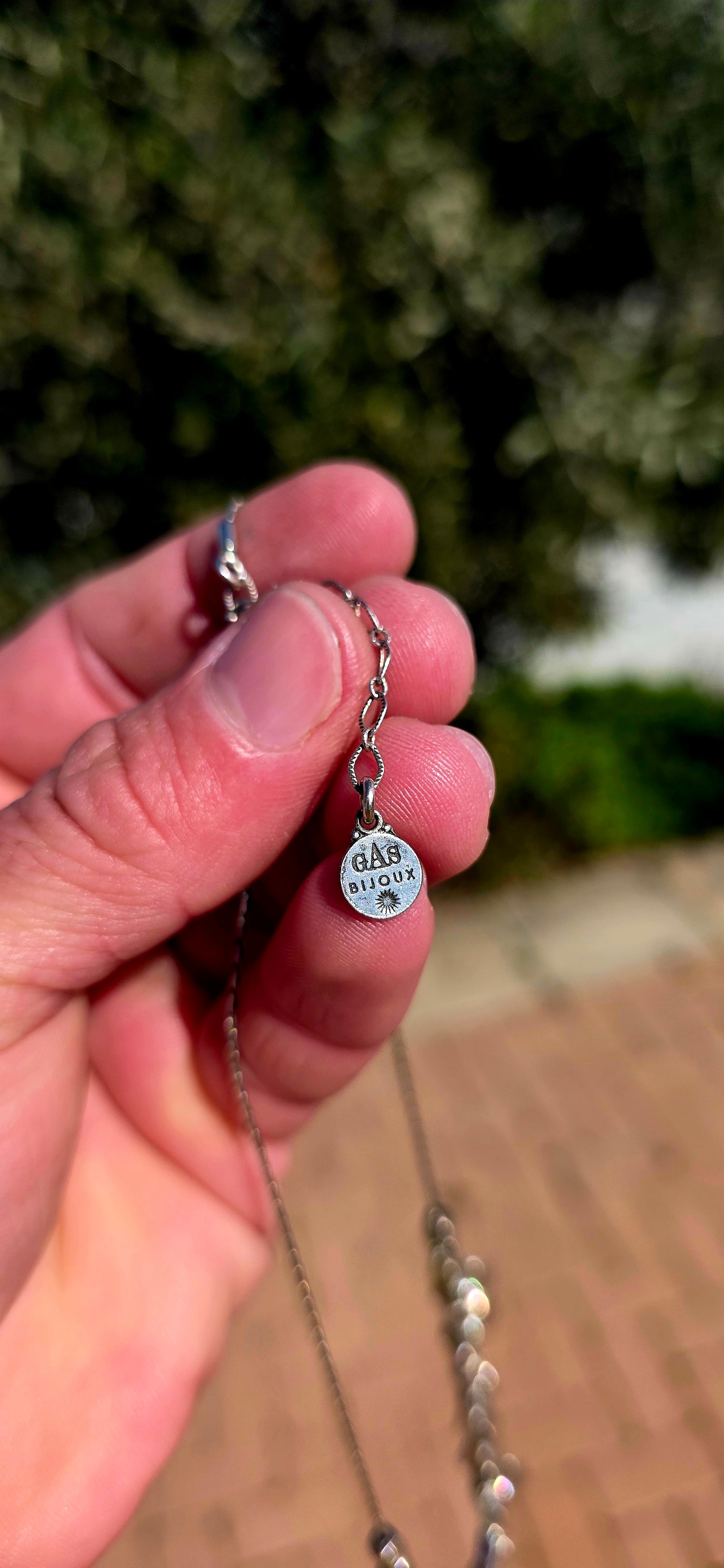 A beautifully feminine statement piece by renowned French jewellery house Gas Bijoux. This designer silver-plated necklace features a graceful row of heart dangles, each adorned with sparkling Swarovski crystal rhinestones in delicate starburst settings.