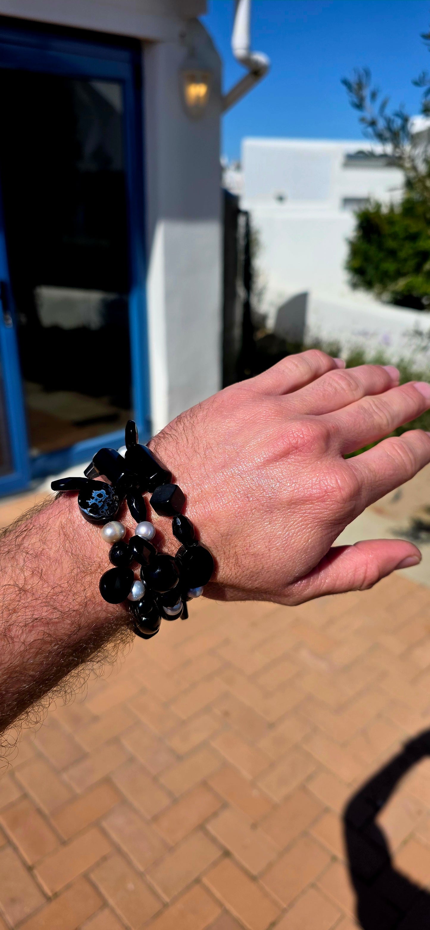 A fabulous collection of chunky gemstone stretch bracelets in dramatic shades of glossy black, beautifully contrasted with luminous freshwater pearls.