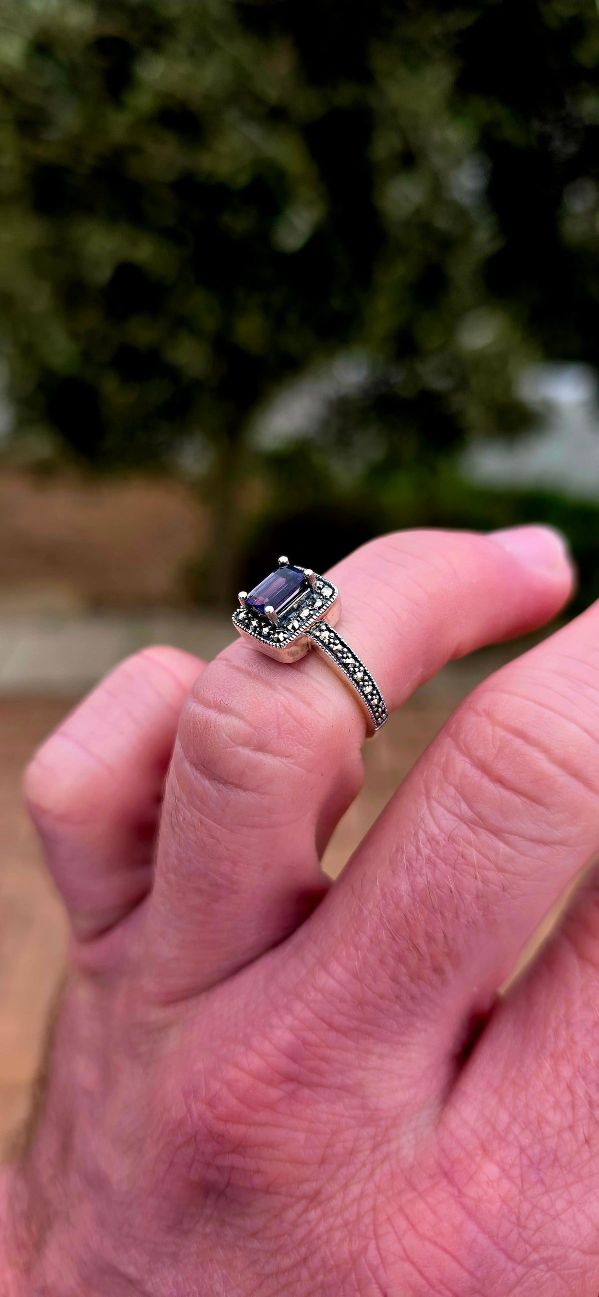Crafted in solid sterling silver, this elegant solitaire ring centres around a beautifully emerald-cut iolite, raised within a classic four-prong setting