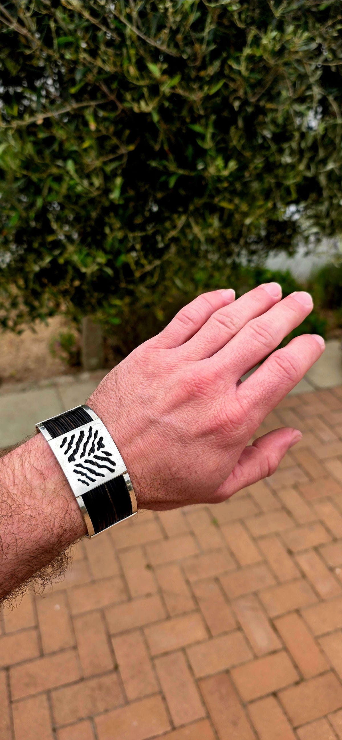 Bold, wonderfully tactile and perfectly UNISEX — this chunky open cuff bracelet combines polished sterling silver with multiple strands of genuine elephant hair, creating a striking contrast between the cool silver and rich dark natural fibres.
