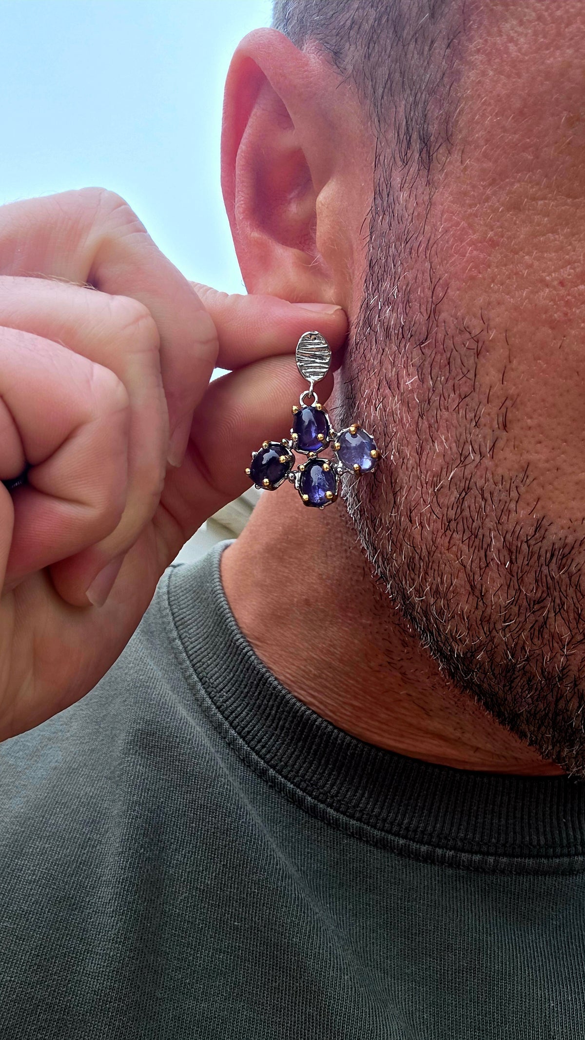 Handcrafted in sterling silver, these artisan drop earrings feature clusters of generously sized oval iolite cabochons, creating a beautifully organic floral formation beneath textured oval stud tops.