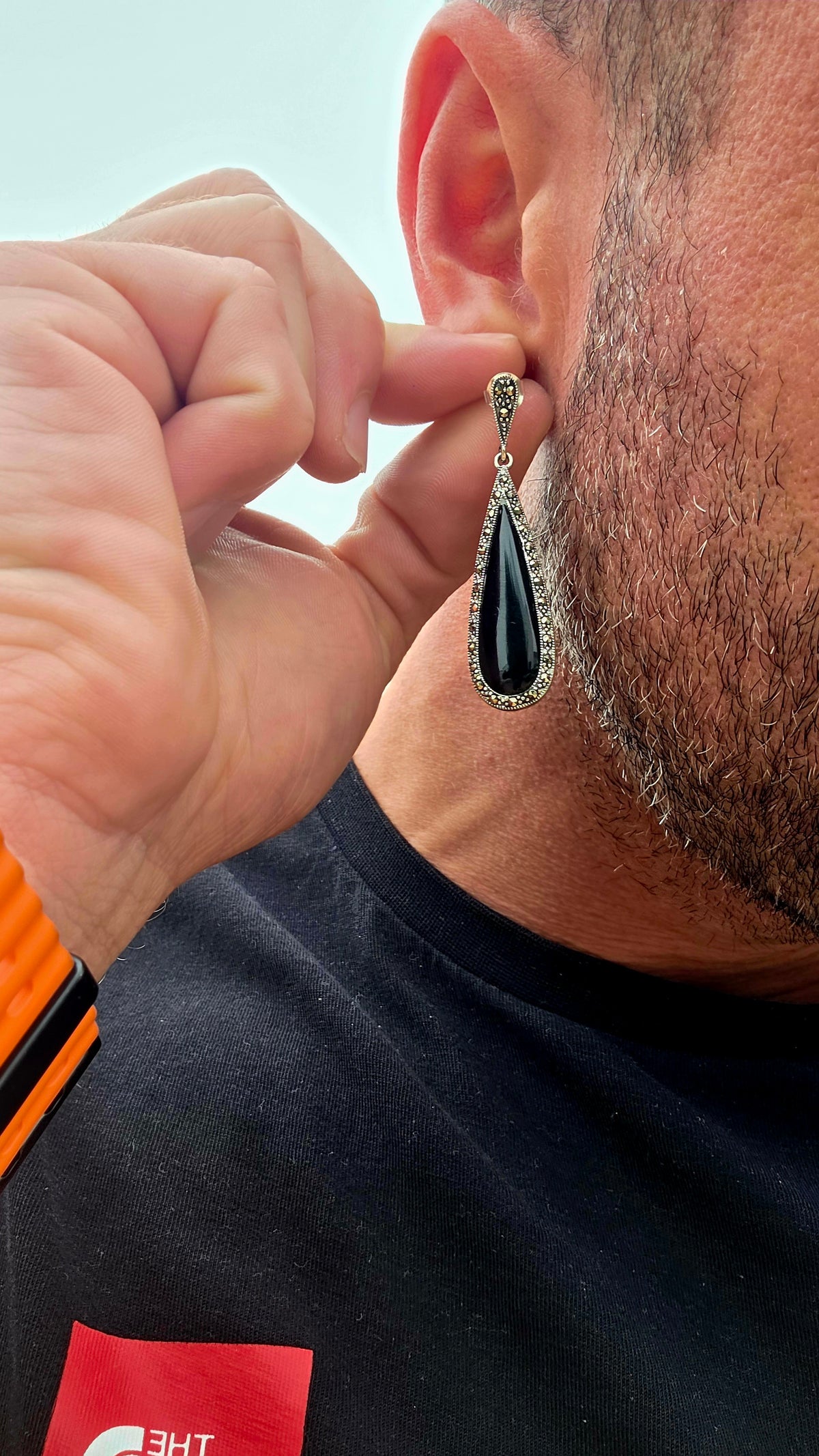 An incredibly elegant pair of Art Deco Revival sterling silver drop earrings, combining dramatic black onyx with the unmistakable sparkle of marcasite.