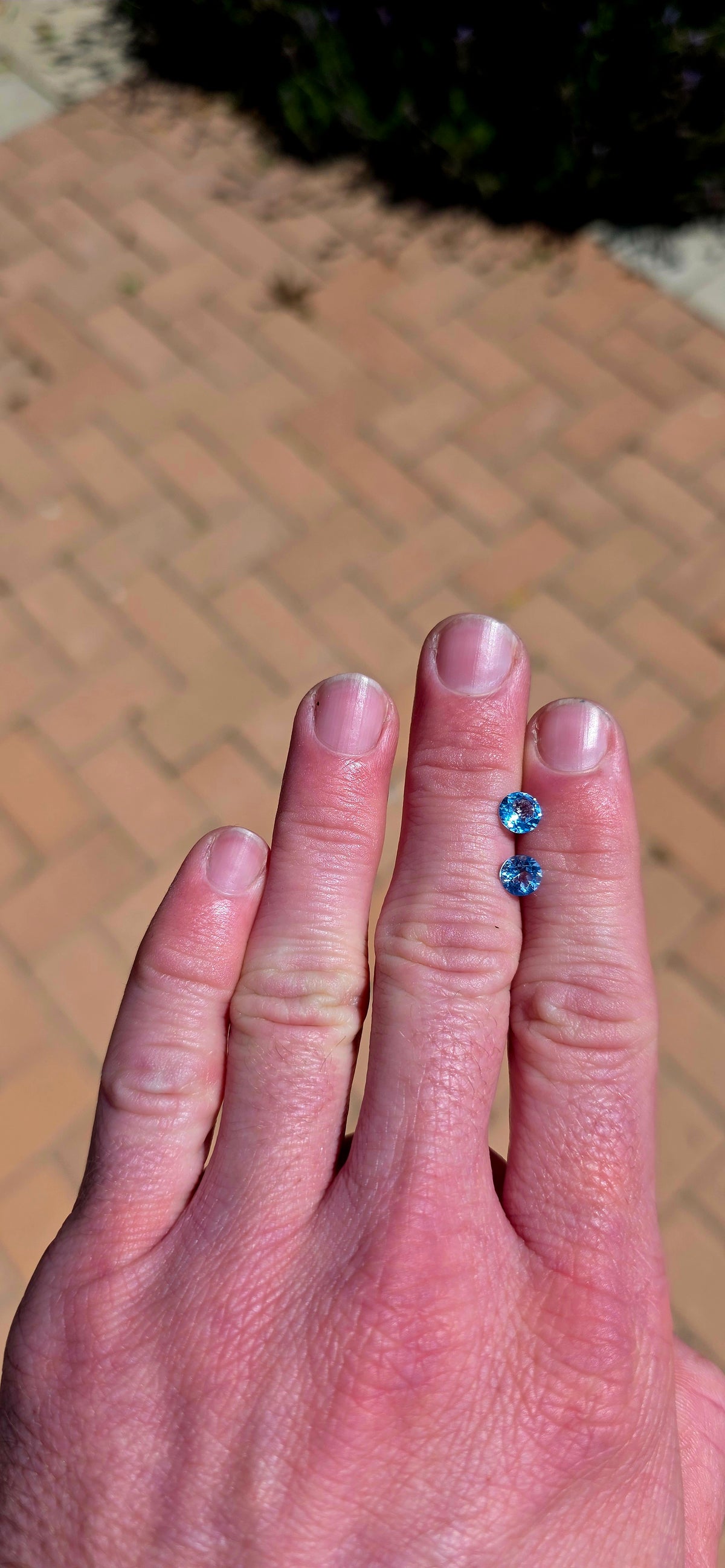 A beautiful matching pair of unset round-cut Sky Blue Topaz gemstones, displaying the most delicate, crystal-clear icy blue colour!