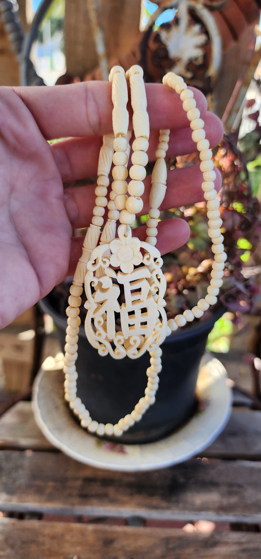 Vintage Chinese necklace features a beautifully Ox Bone carved "Good Fortune" symbol pendant with hand-carved beads.