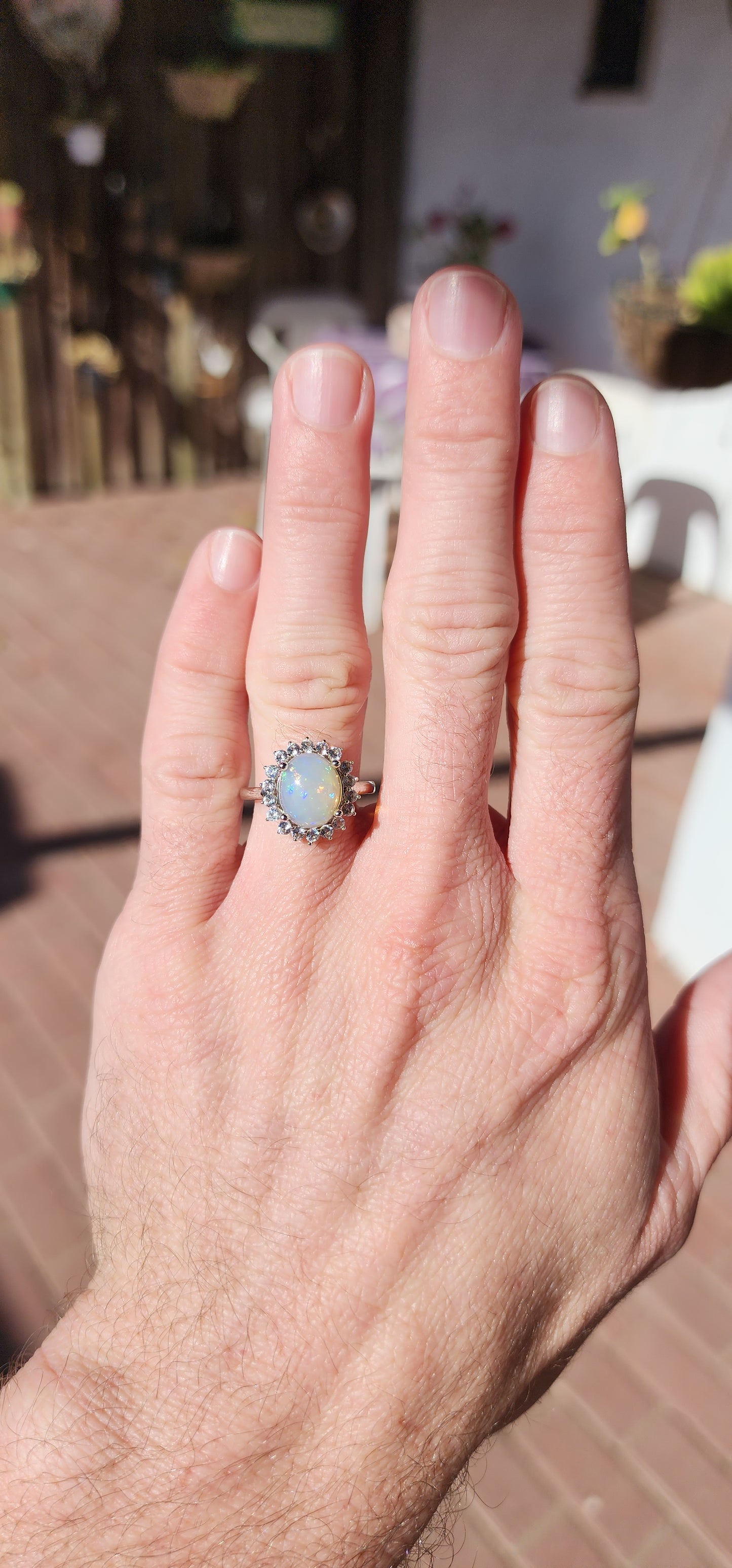 Sterling Silver ,Ethiopian Welo Opal and Clear CZ Gemstone dress Ring .The lovely and generous in size Opal Cabochon has been claw set in an Sparkly Round CZ Haló border.