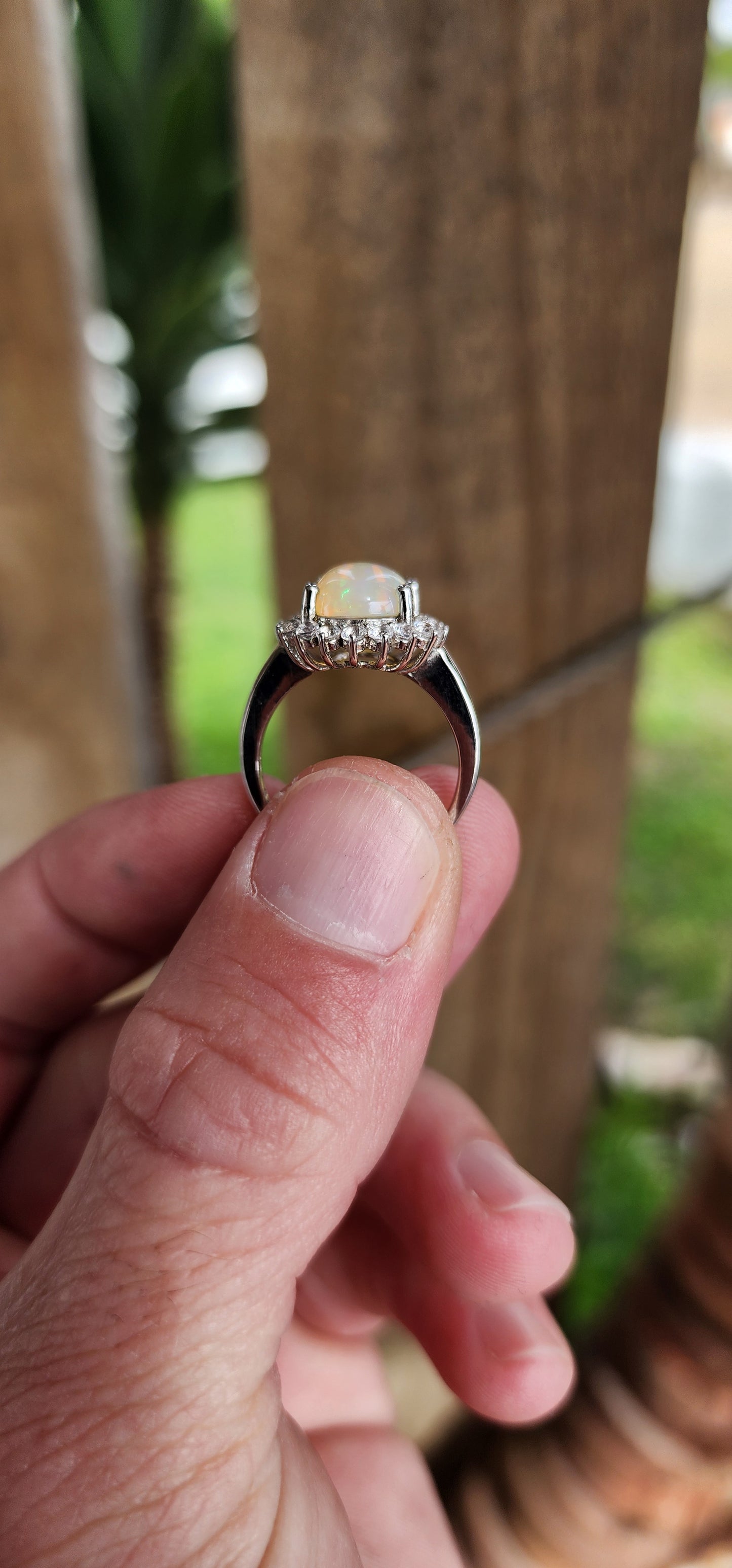 Sterling Silver ,Ethiopian Welo Opal and Clear CZ Gemstone dress Ring .The lovely and generous in size Opal Cabochon has been claw set in an Sparkly Round CZ Haló border.