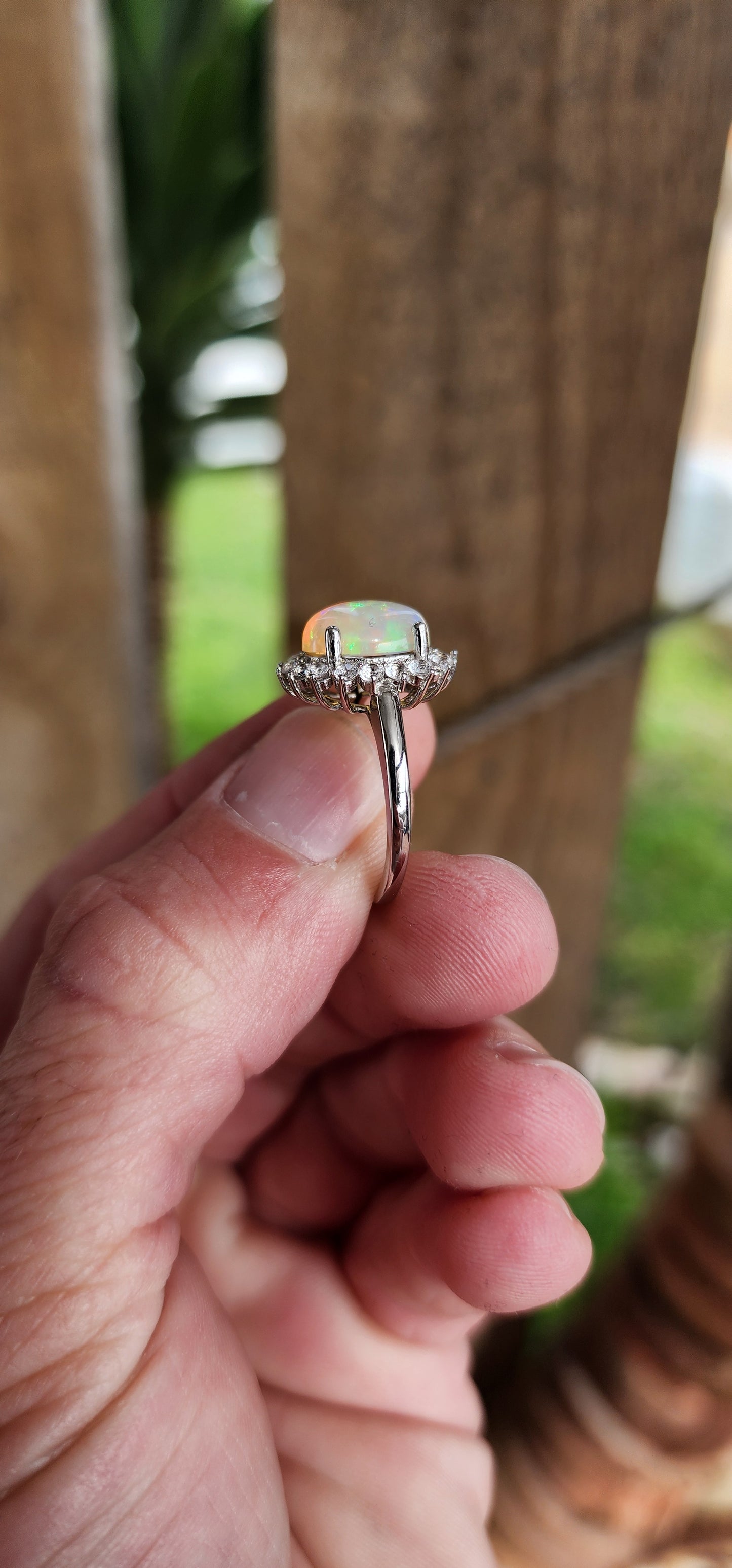 Sterling Silver ,Ethiopian Welo Opal and Clear CZ Gemstone dress Ring .The lovely and generous in size Opal Cabochon has been claw set in an Sparkly Round CZ Haló border.