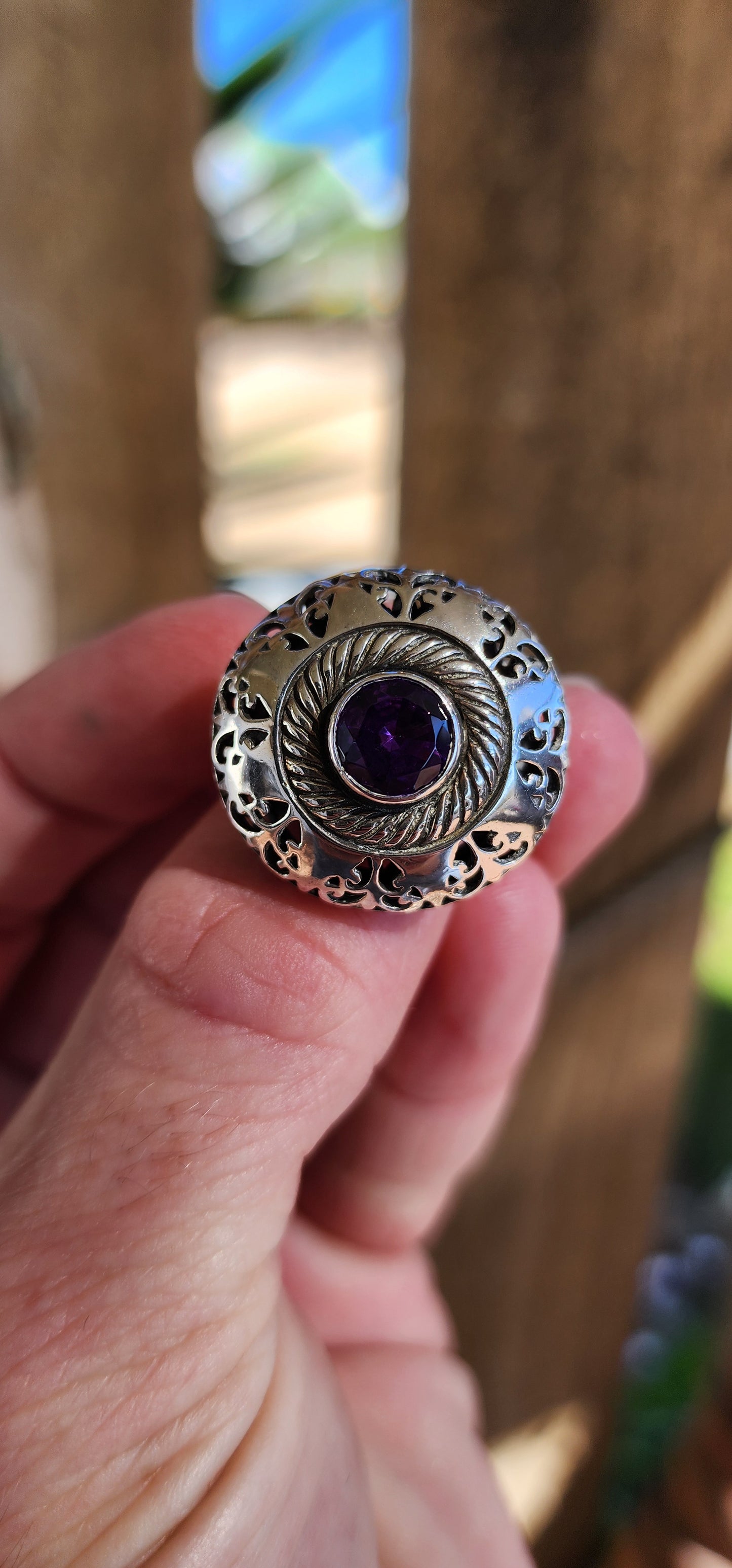 Marvelous and chunky Sterling Silver cocktail/dress ring.An Round cut Amethyst centers the domed design , ornate hand pierced detail spill over from the crown to the shoulders of the band.