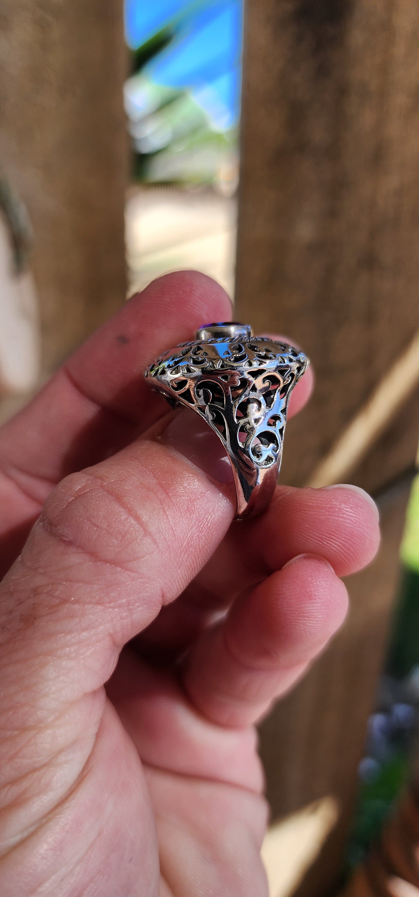 Marvelous and chunky Sterling Silver cocktail/dress ring.An Round cut Amethyst centers the domed design , ornate hand pierced detail spill over from the crown to the shoulders of the band.