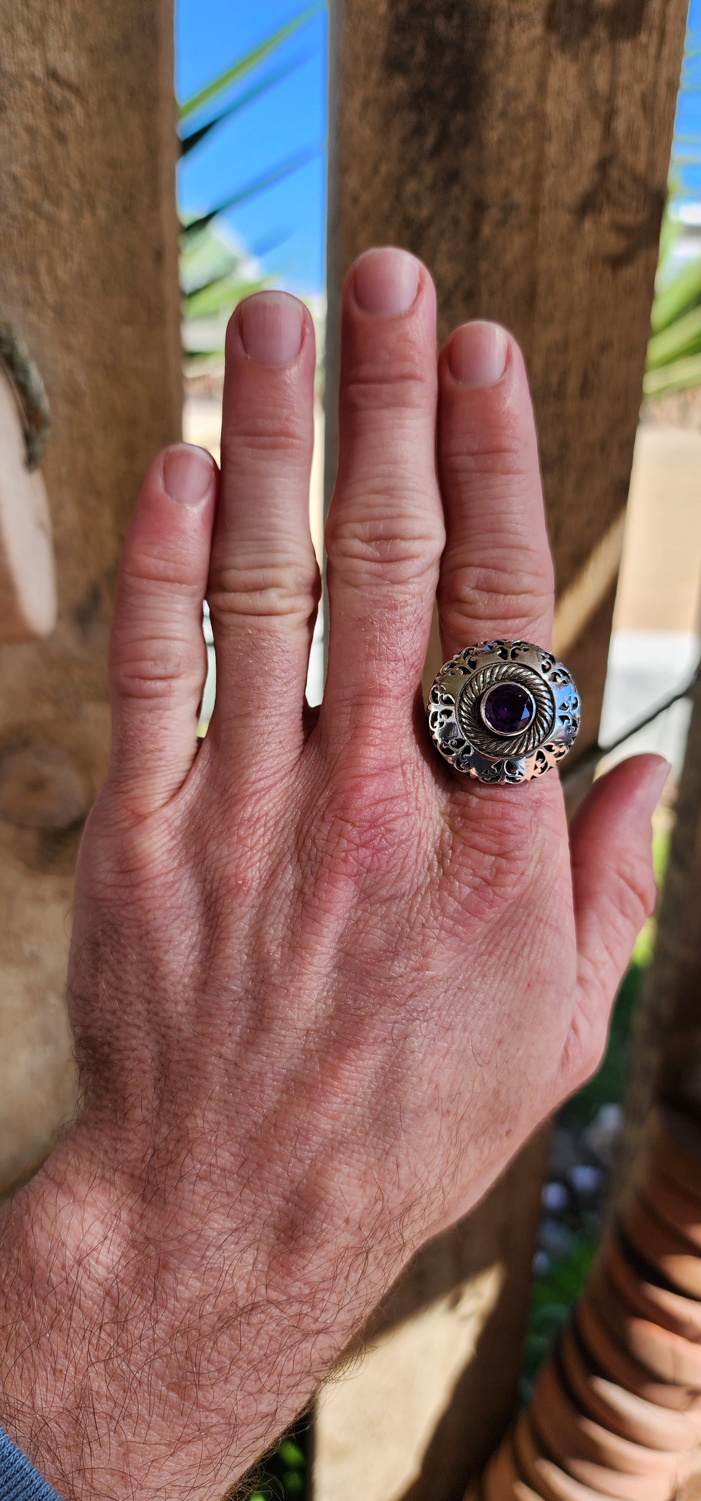 Marvelous and chunky Sterling Silver cocktail/dress ring.An Round cut Amethyst centers the domed design , ornate hand pierced detail spill over from the crown to the shoulders of the band.