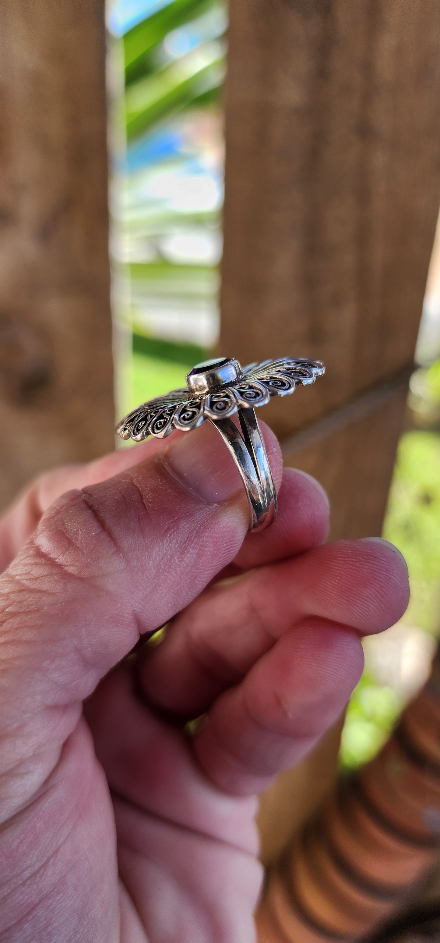 Sterling Silver and Amethyst openwork Floral Coktail/dress ring.
A Sparkling Purple Amethyst forms the center of a large statement flower. The intricate petals offer an eye-catching allure.