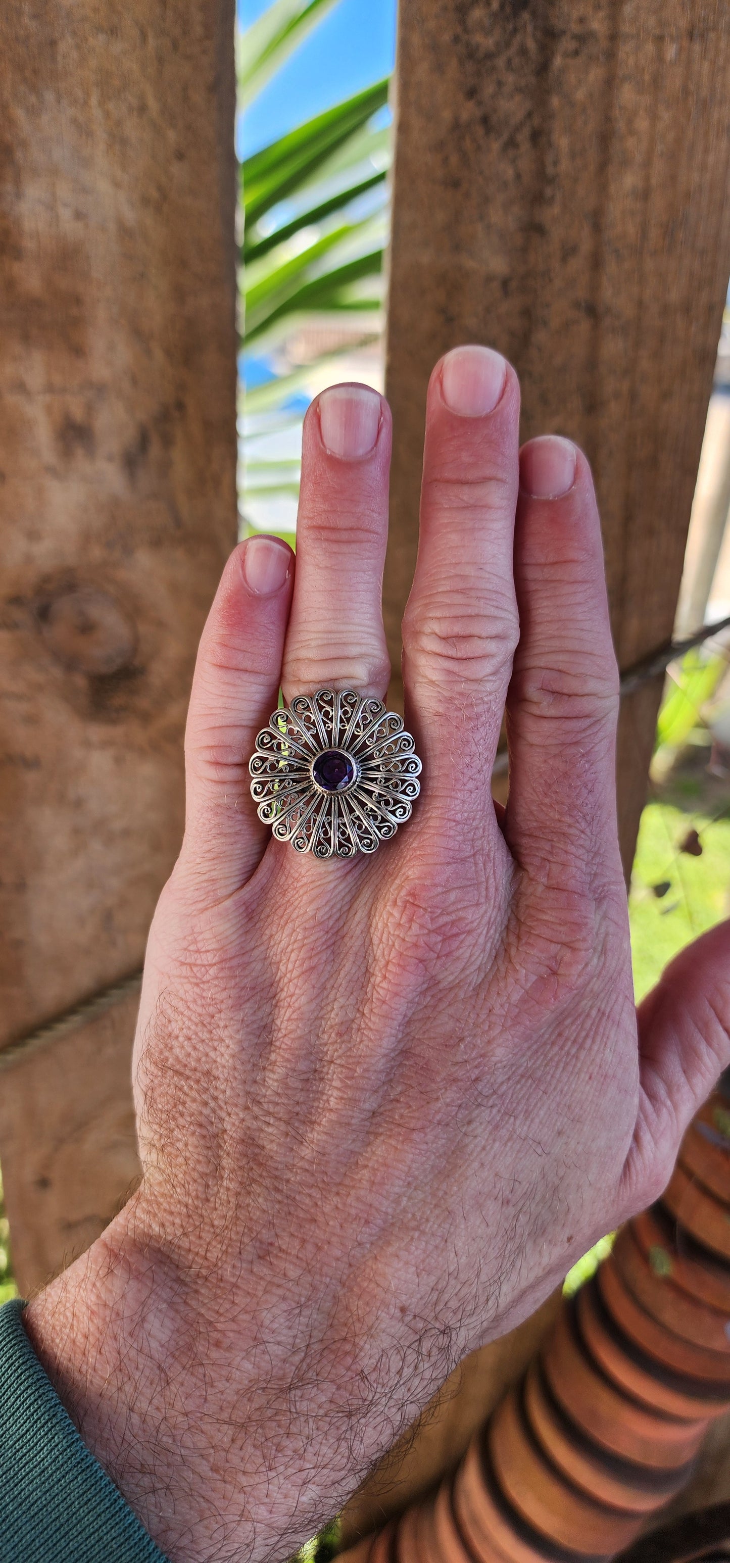 Sterling Silver and Amethyst openwork Floral Coktail/dress ring.
A Sparkling Purple Amethyst forms the center of a large statement flower. The intricate petals offer an eye-catching allure.