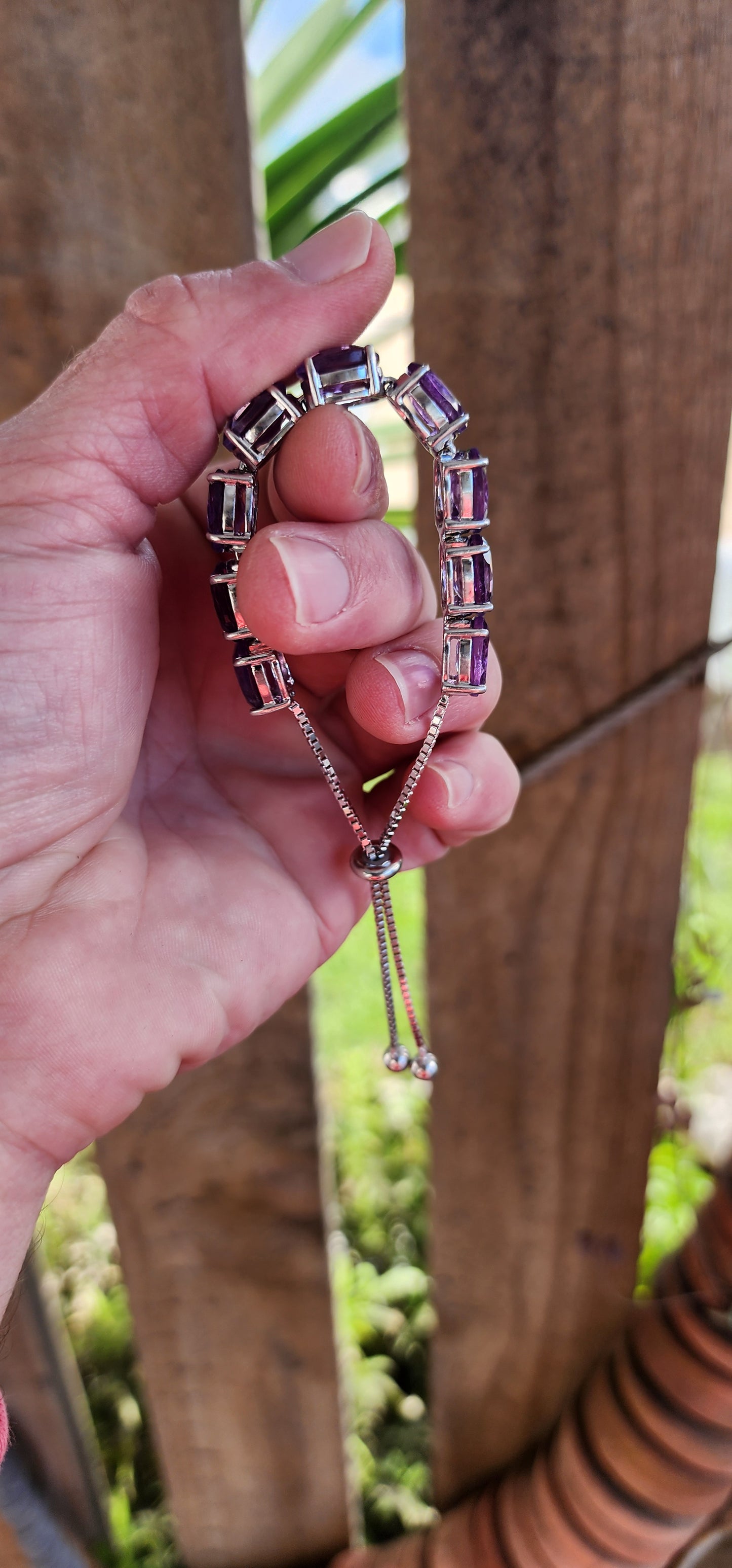 This gorgeous and STATEMENT Tennis style bracelet is crafted in Sterling Silver and features 9x large sized Oval Faceted Cut Amethyst Gemstones, claw set and studded together in an Tennis style, to give it a bold and stylish look.