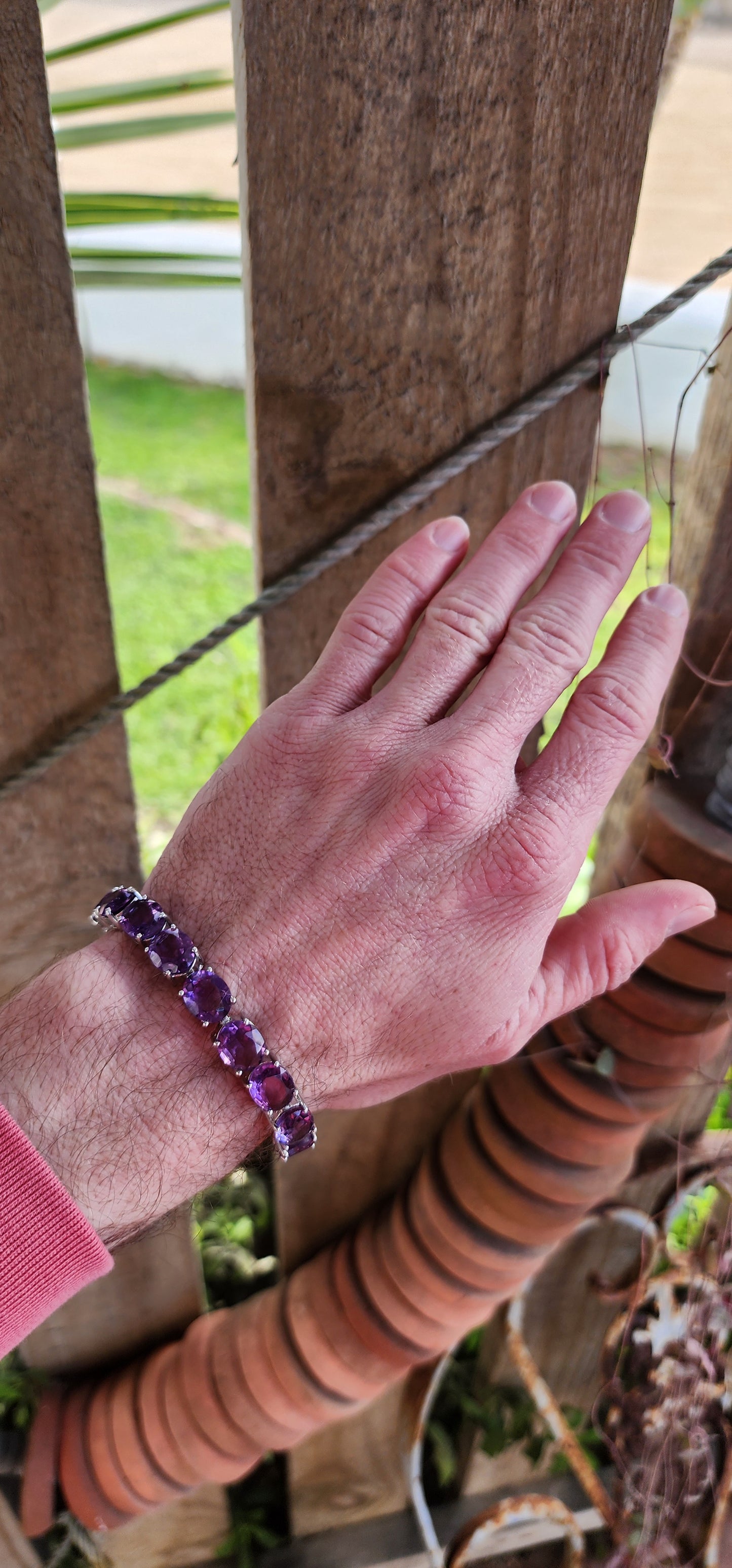 This gorgeous and STATEMENT Tennis style bracelet is crafted in Sterling Silver and features 9x large sized Oval Faceted Cut Amethyst Gemstones, claw set and studded together in an Tennis style, to give it a bold and stylish look.