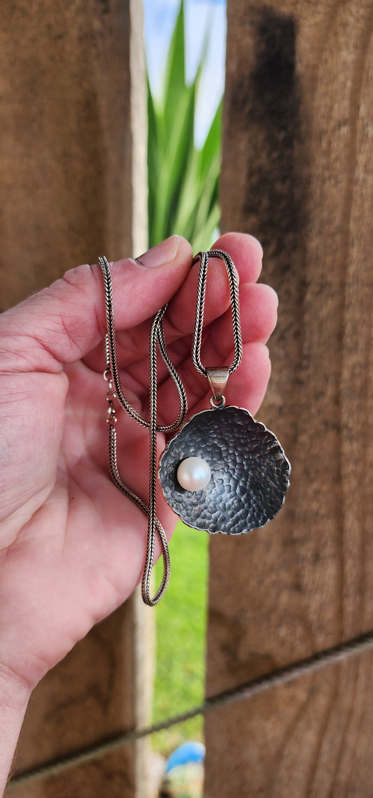 Unusual Artisan/Studio made Sterling Silver Modernist/Brutalist textured/hammered concave Round pendant with an Cultured Pearl , oxidised with an lovely Black patina.Fitted on an Sterling Silver Foxtail chain.