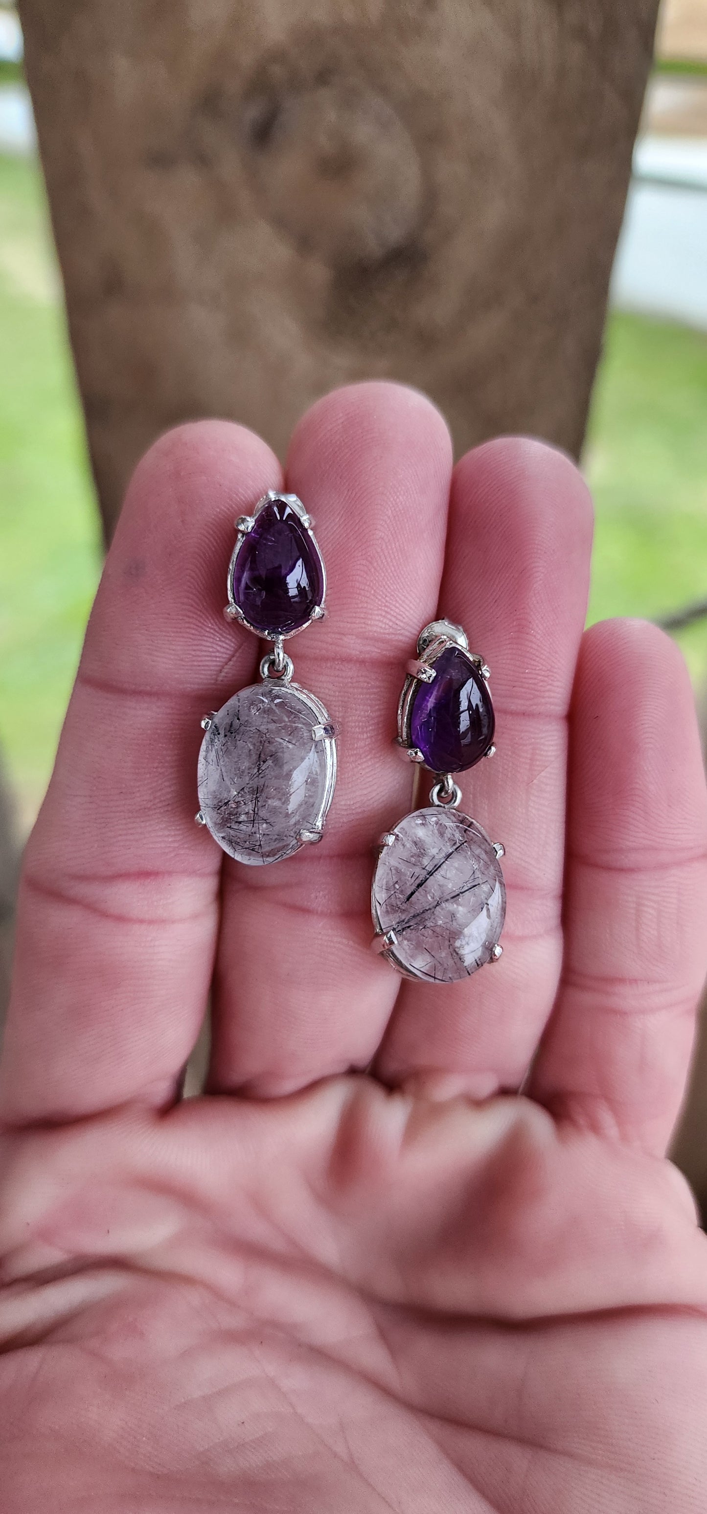 Marvelous pair of Sterling Silver drop earrings.These push-in earrings feature generous in size Oval Rutilated Quartz cabochon drops that are claw set in open Gallery baskets ,suspended from claw set Pear cut Amethyst Cabochons.