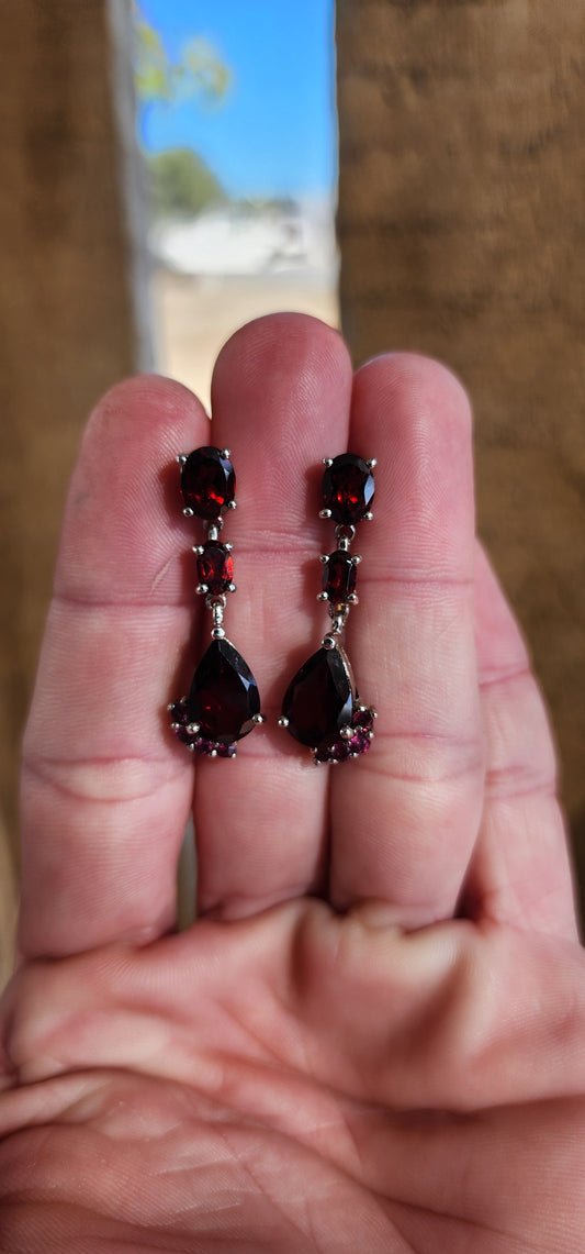 Pleasing pair of Sterling Silver and Garnet/Tourmaline Gemstones push-in drop earrings.Each Claw set with a Pear Cut Garnet drop with an added cluster of 4 Pink Tourmaline Gemstones on the sides, suspended from a line drop of 2x Oval Cut Garnet Gemstones.