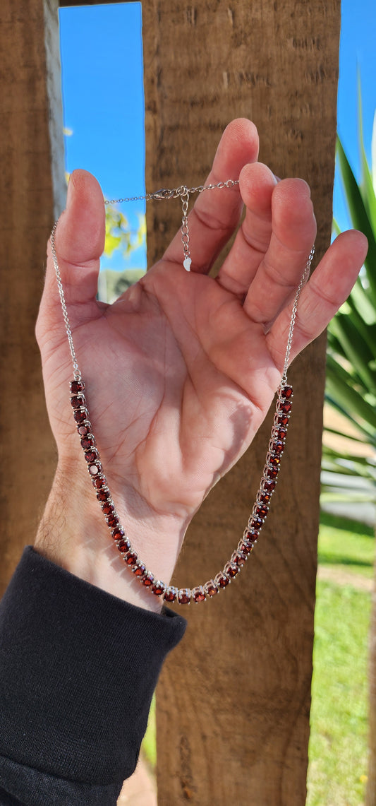 Beautiful Sterling Silver and Garnets Tennis style Necklace prong set with 37x generous in size Round cut Garnets in open gallery baskets.The Garnets each measure 5mm in diameter.The Tennis necklace fitted with a adjustable length chain and lobster clasp.