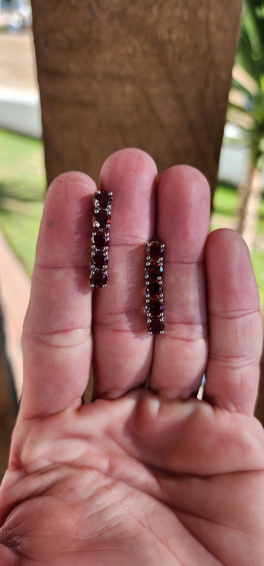 Pretty and elegant Sterling Silver and Garnets push-in dangle earrings each prong set with 5x Round cut Garnets in open gallery settings.The Garnets each measure 5mm in diameter.The earrings come with Sterling Silver studs/butterflies.