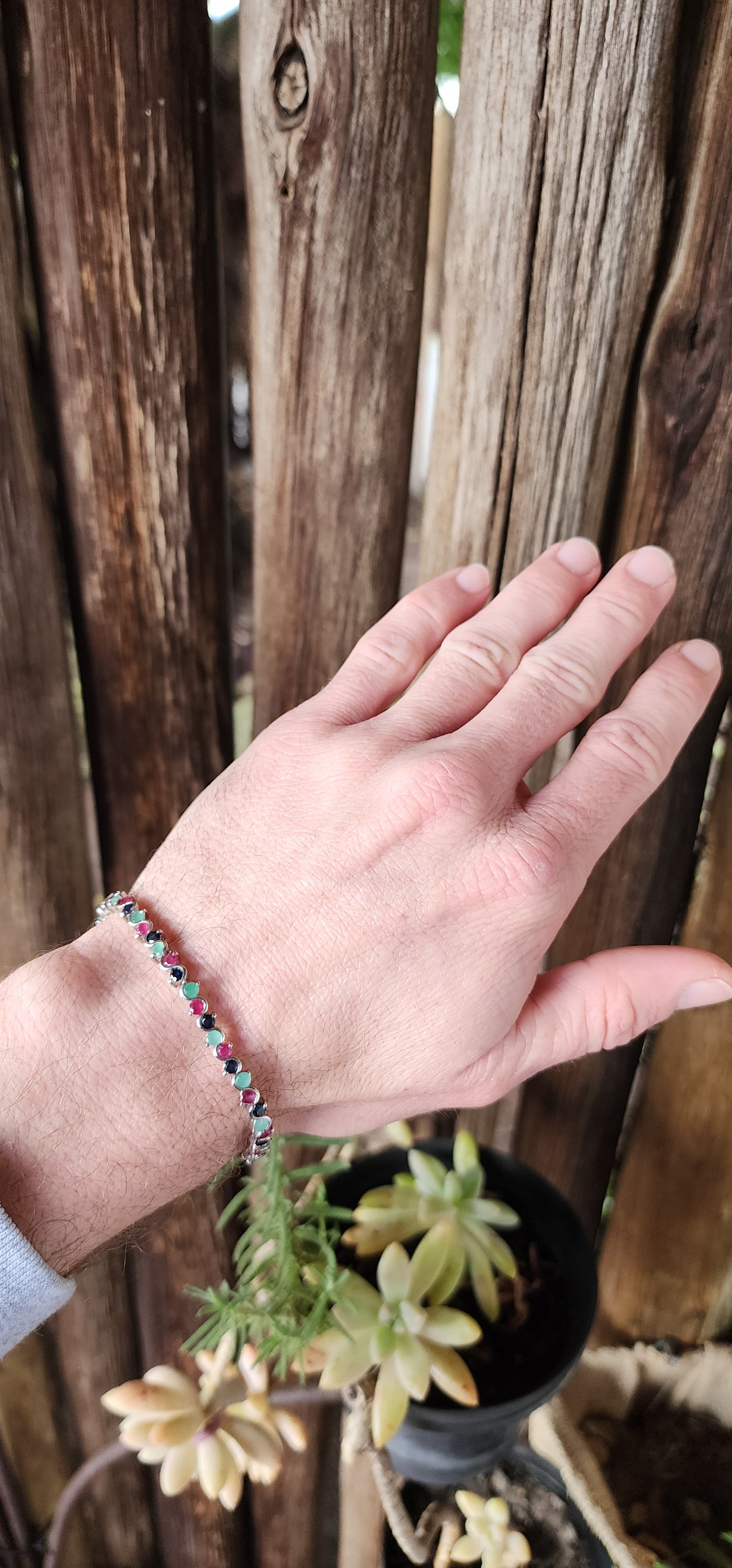 Classical beauty!This alluring Tennis bracelet is crafted in lustrous Sterling Silver and features 48x claw/tube set Natural Round Cut Rubies,Emeralds and Sapphire Gemstones in a curved wave design.Fitted with a ornate pierced clip clasp.