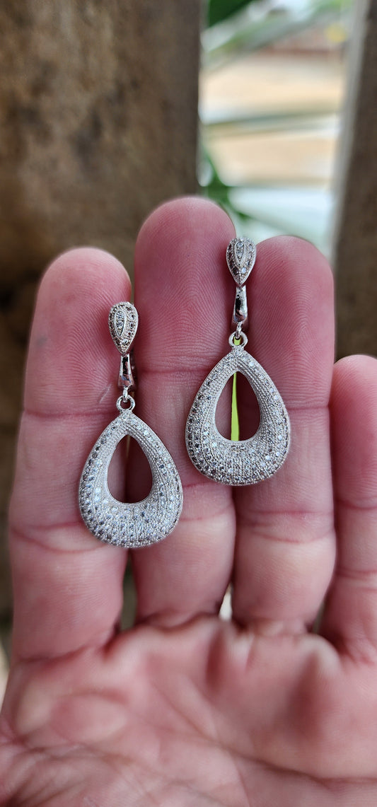 Pleasing pair of Sterling Silver Teardrop dangle earrings - Micro Pave set with multiple sparkly CZ Gemstones completely covering the surfaces of the Teardrops.