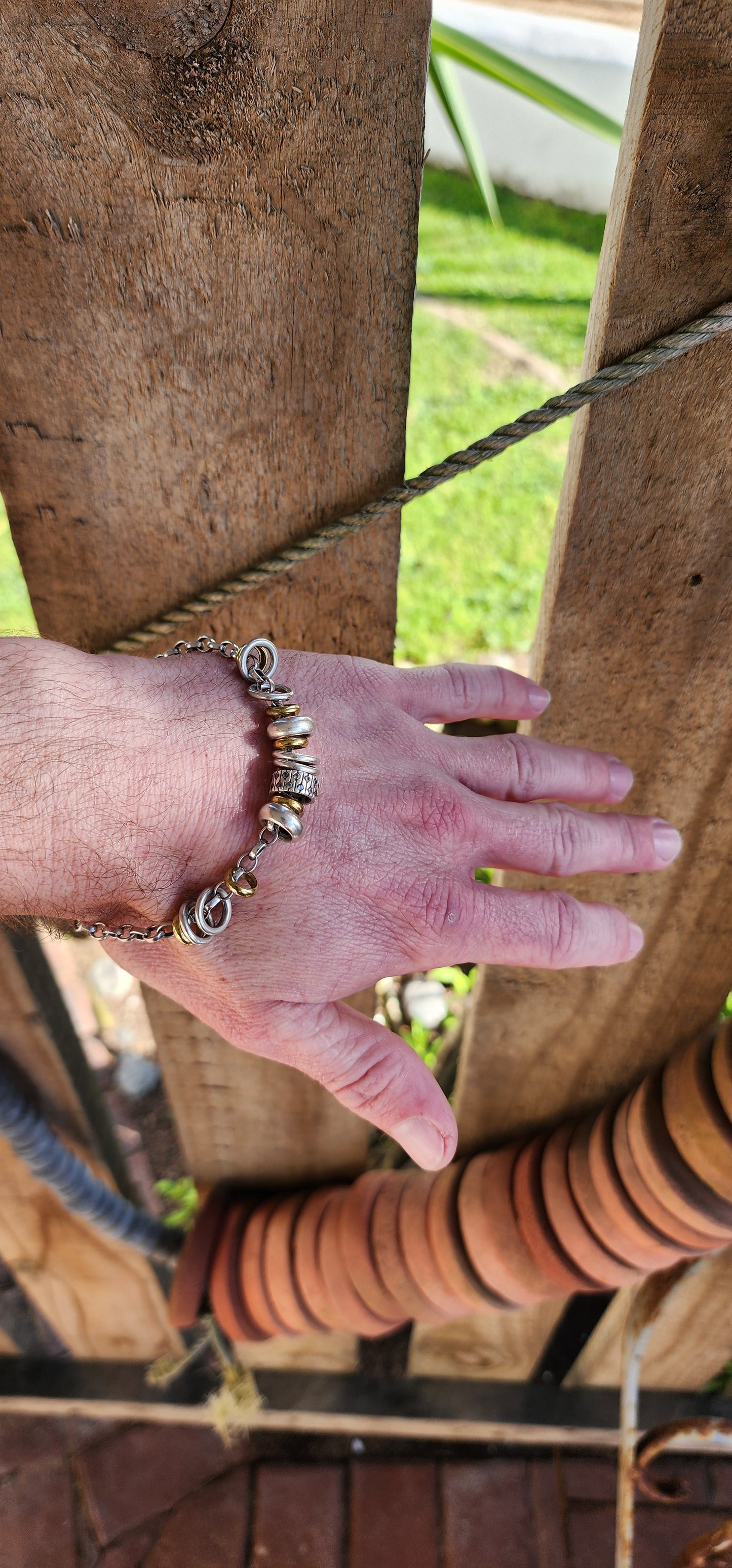 Beautiful and unusual Italian made Rolo link bracelet - Adorned with Sterling Silver ring charms in different widths , the 6 smaller rings being 9ct Yellow Gold and the widest Silver ring in the center flush set with clear CZ Gemstones right-around.