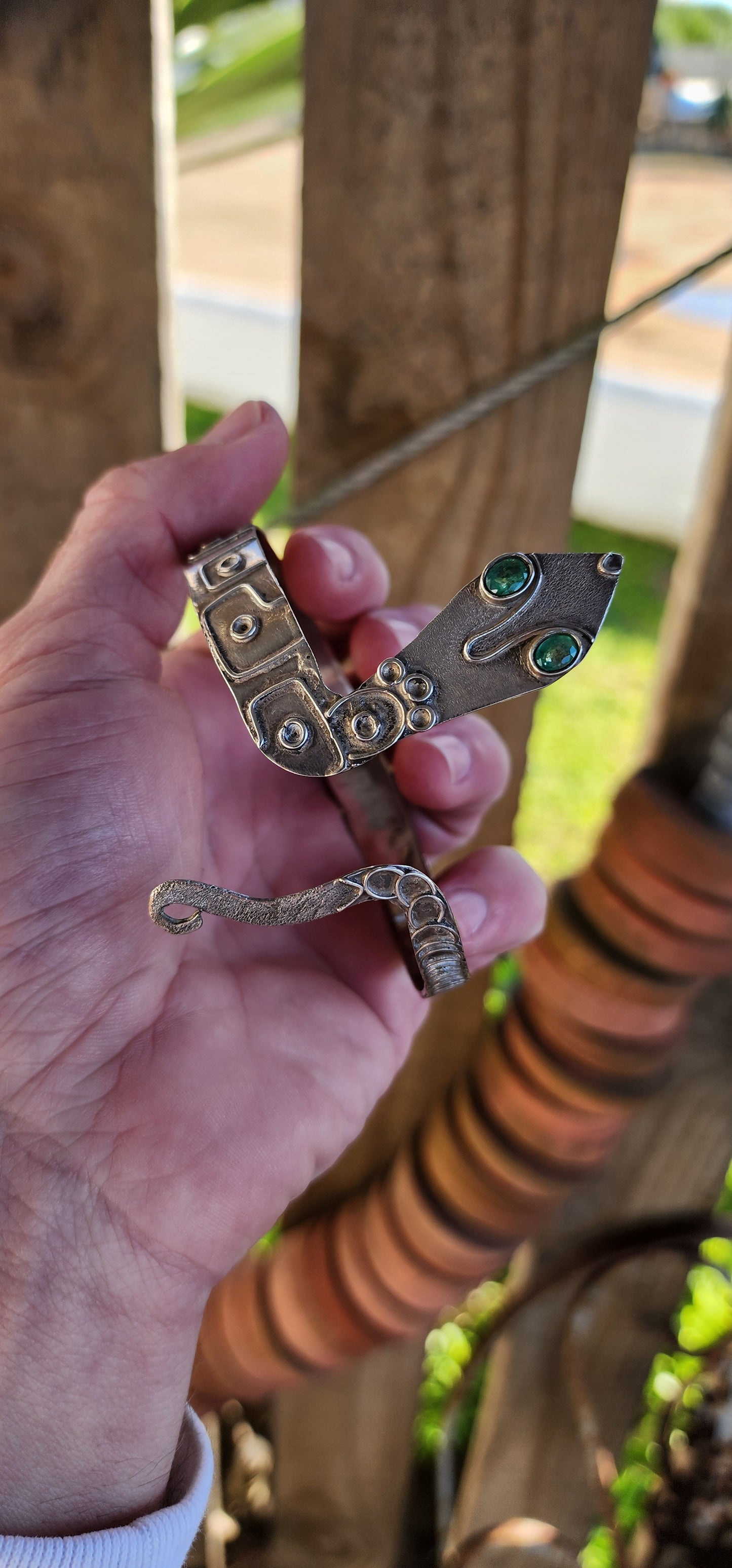 Vintage Egyptian Revival Arts and Crafts movement upper arm Serpent bracelet - Crafted in Sterling Silver with a embossed patterned body/tail, the Serpents eyes have been set with Natural Oval cut Emeralds in bezel/tube settings.