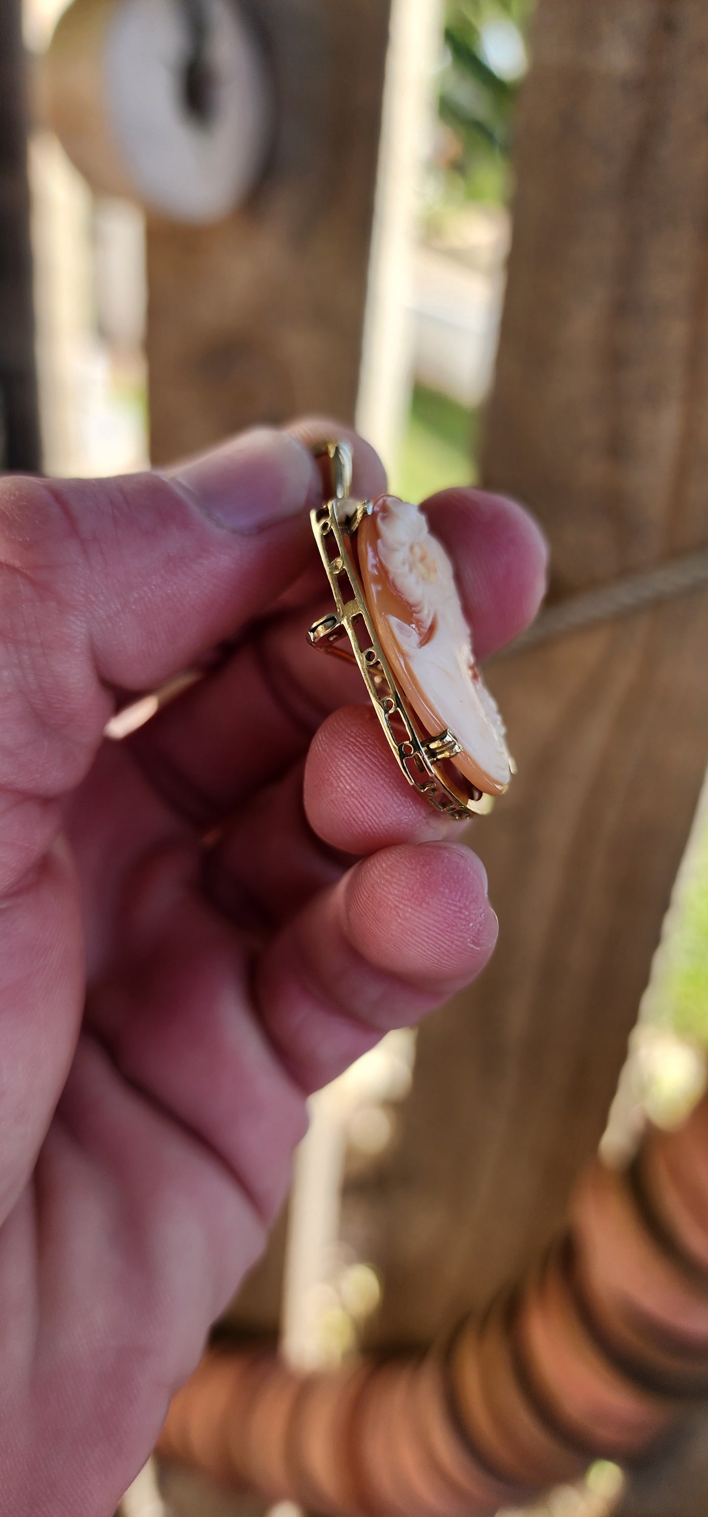 Beautiful Vintage hand carved Shell Cameo brooch/Pendant. The masterfully carved Cameo depicting a portrait of a elegant right facing lady with a flower in her hair .The Cameo has been prong set in a 10ct Yellow Gold Rounded Rectangular shape frame.