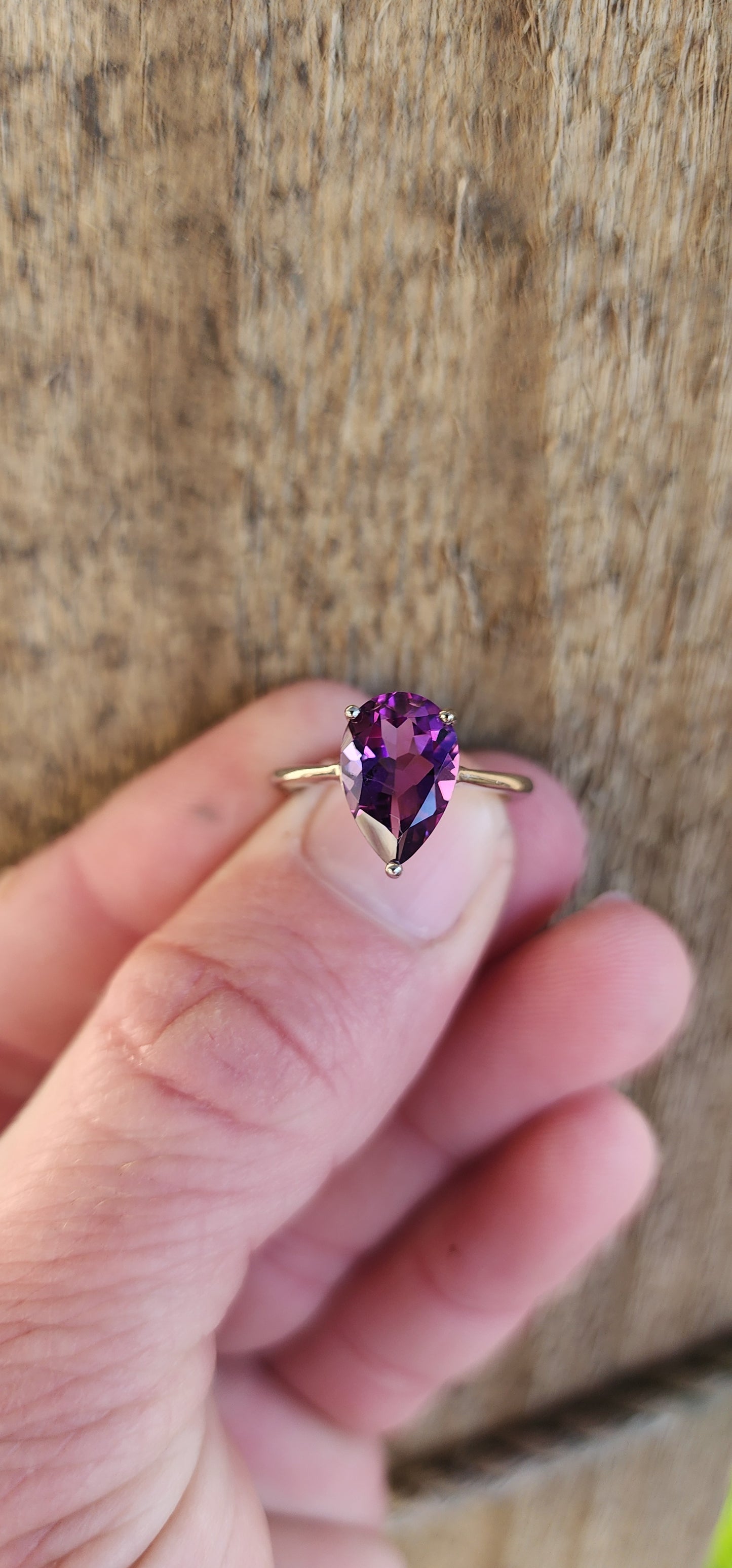 Sterling Silver Solitaire ring claw set with a Pear cut Amethyst Gemstone in a open Gallery basket.